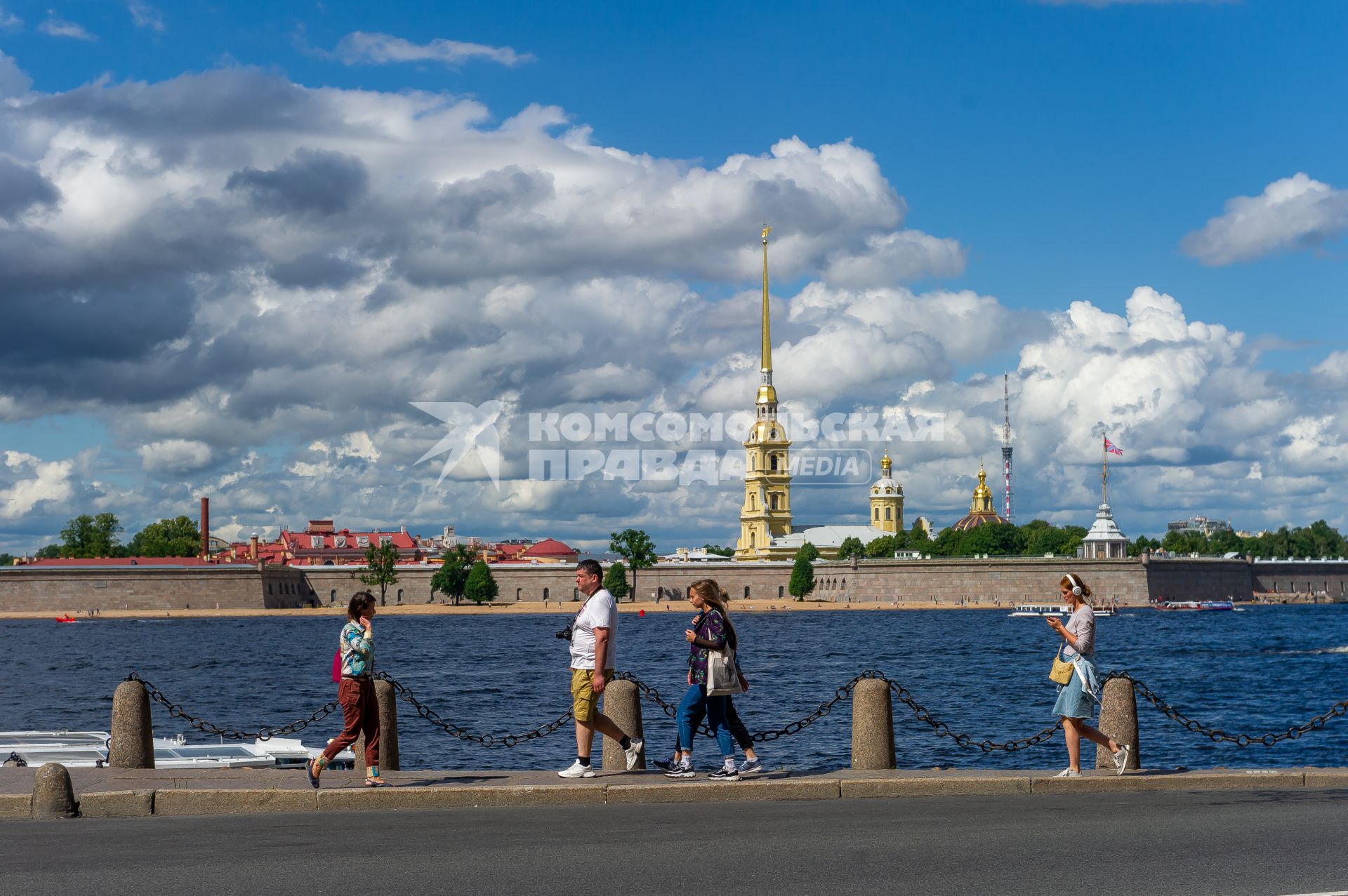 Санкт-Петербург. Люди гуляют на набережной с видом на Петропавловскую крепость.