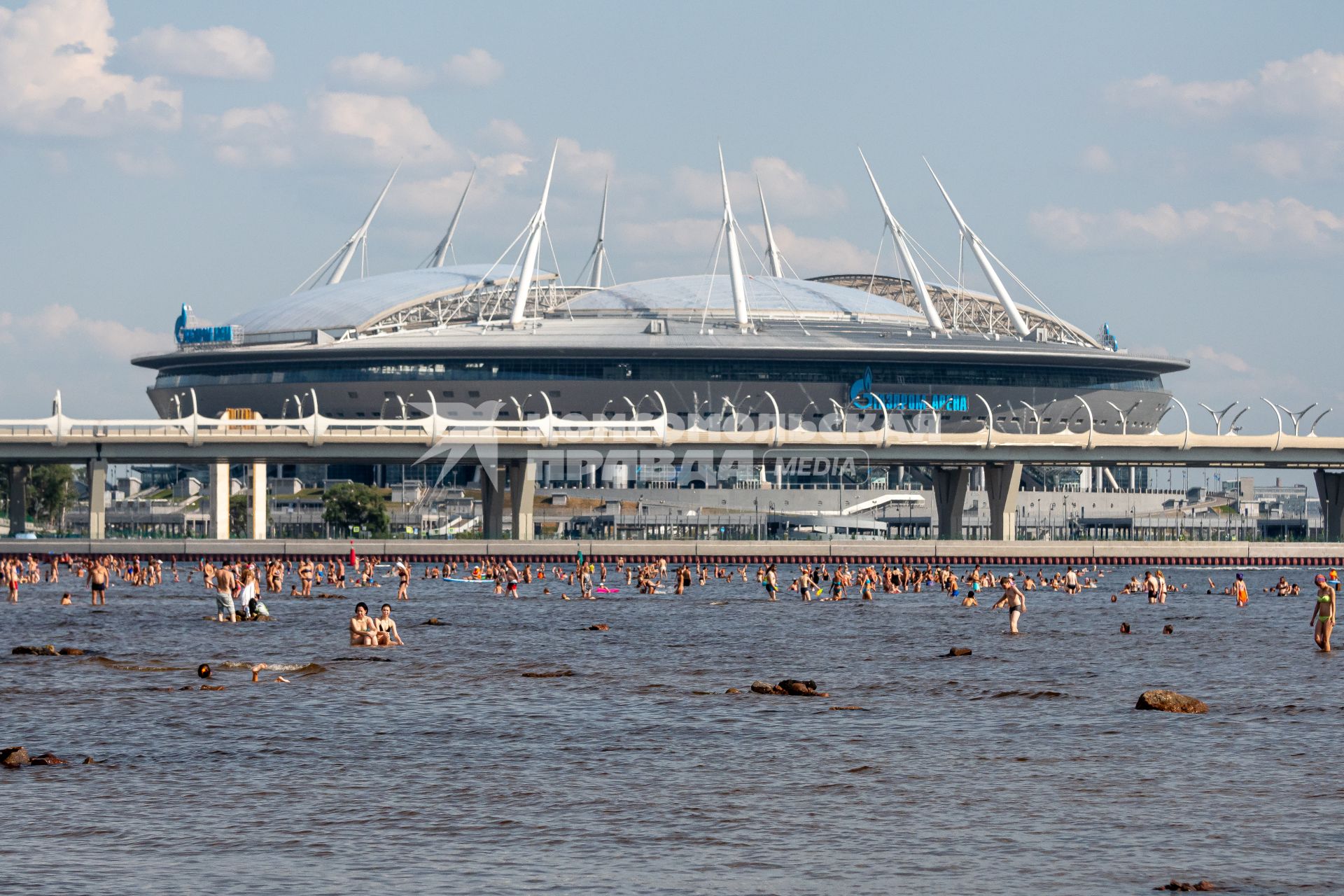 Санкт-Петербург. Люди купаются в Финском заливе с видом на стадион `Газпром-Арена`.