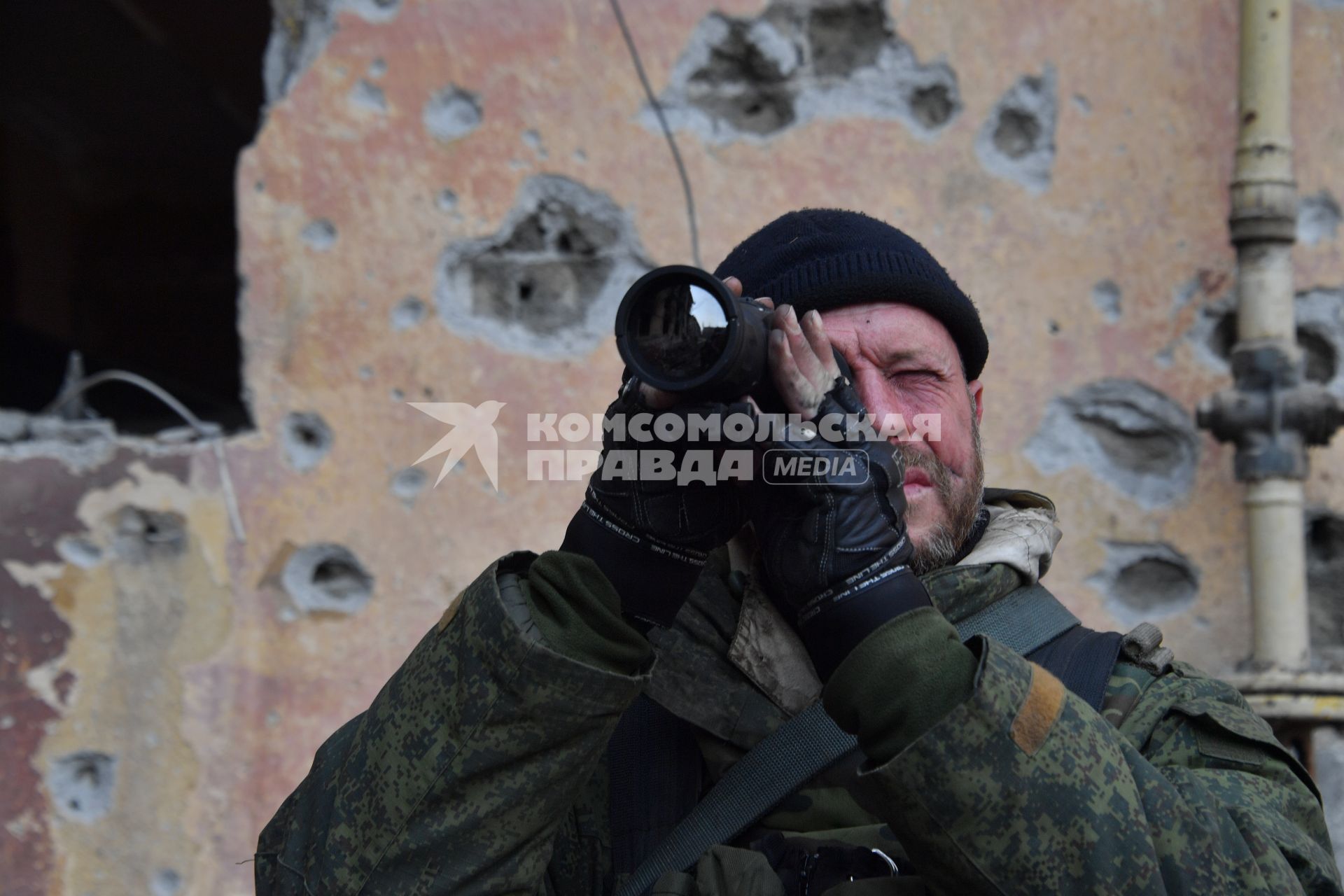 Донецкая область. г.Мариуполь. Военнослужащий ДНР осматривает местность с помощью монокуляра.