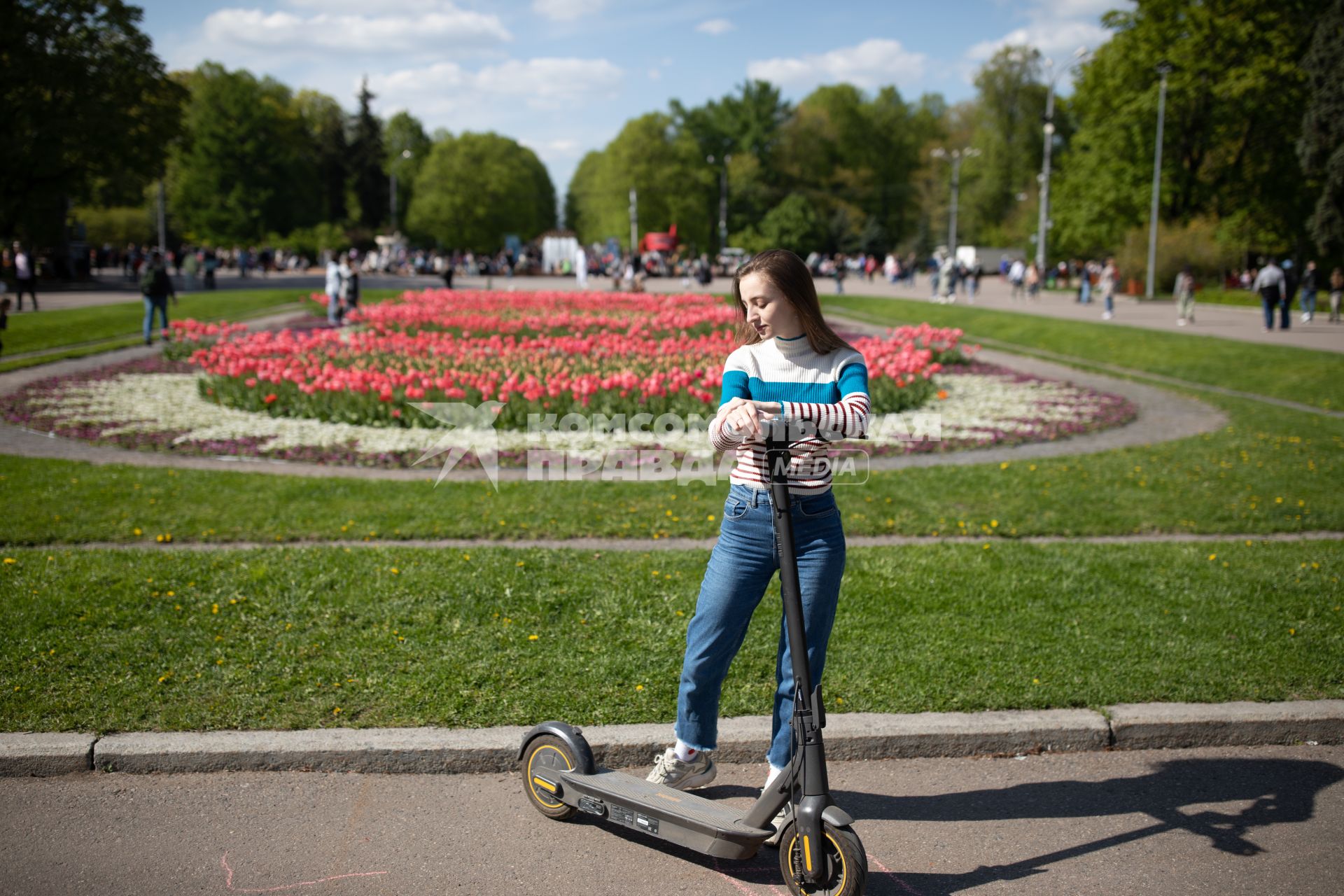 Москва. Девушка на самокате в парке.