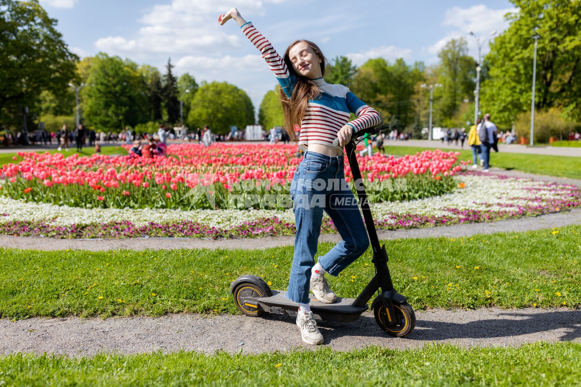 Москва. Девушка на самокате в парке.