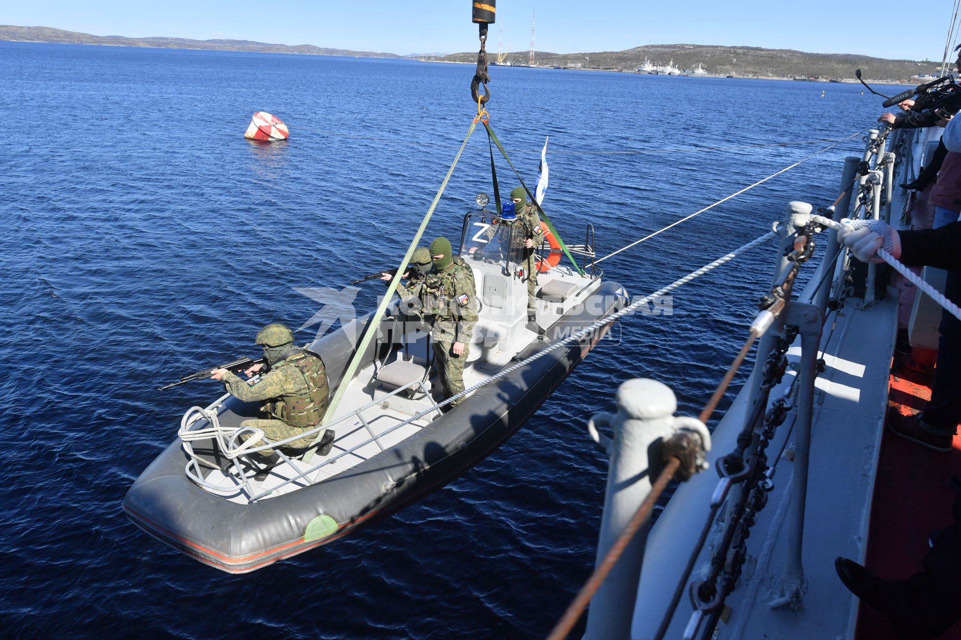 Североморск. Военнослужащие морской пехоты ВМФ РФ спускаются на воду в моторной лодке  с борта тяжёлого атомного ракетного крейсера  Петр Великий во время учений .