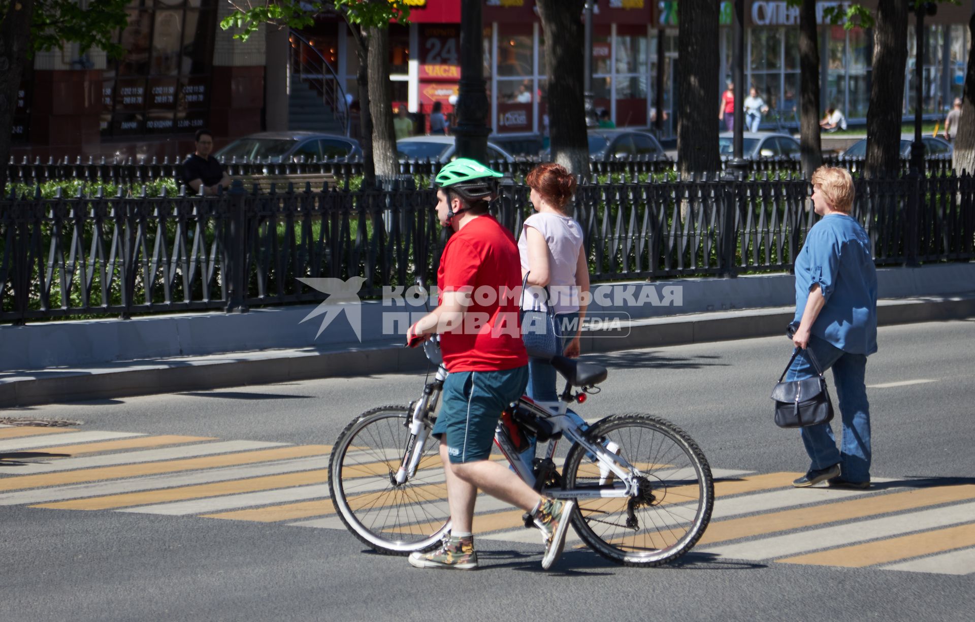 Пермь. Велосипедист переходит дорогу по пешеходному переходу.