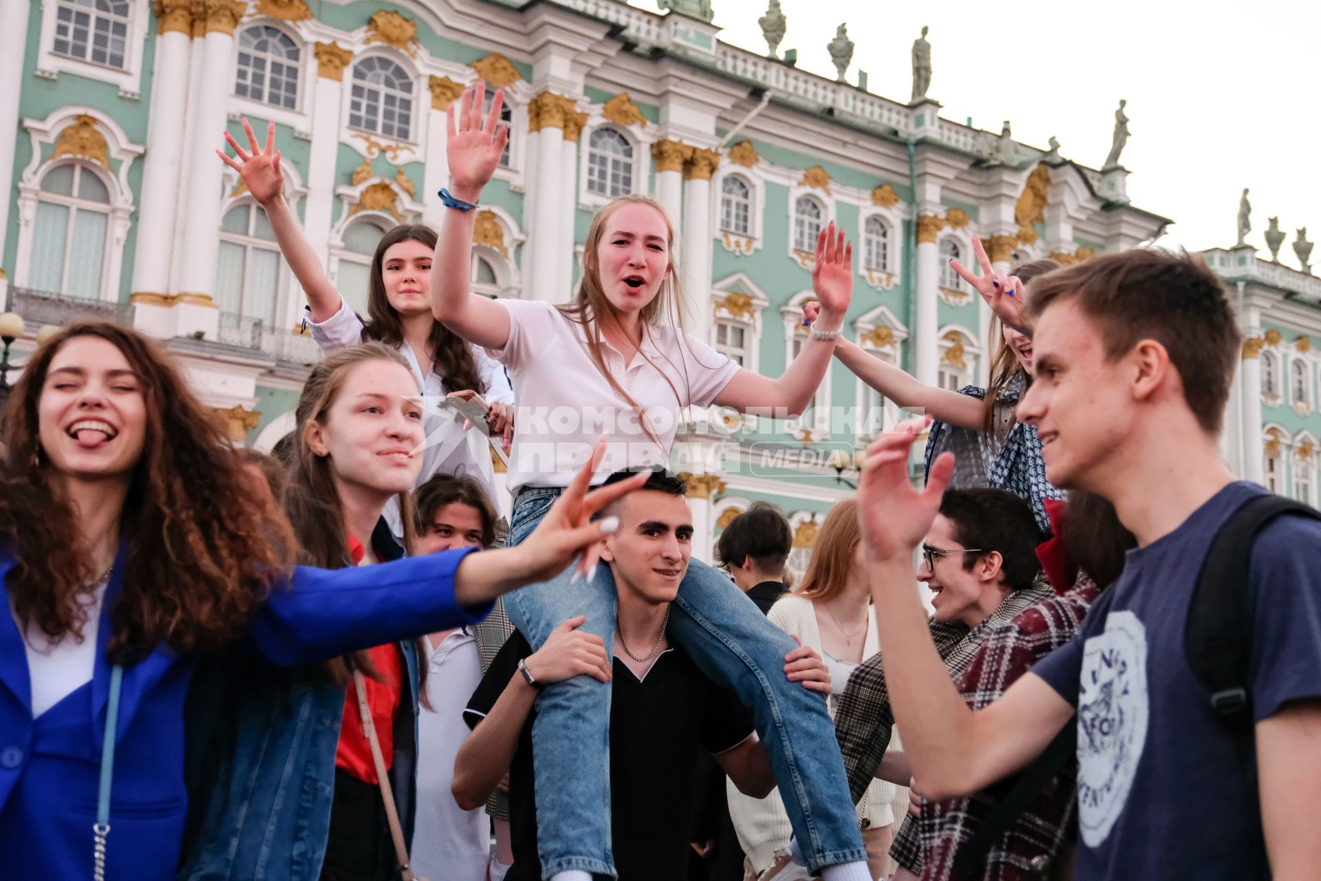 Санкт-Петербург.  Молодые люди на Дворцовой площади перед началом праздника  выпускников`Алые паруса`.