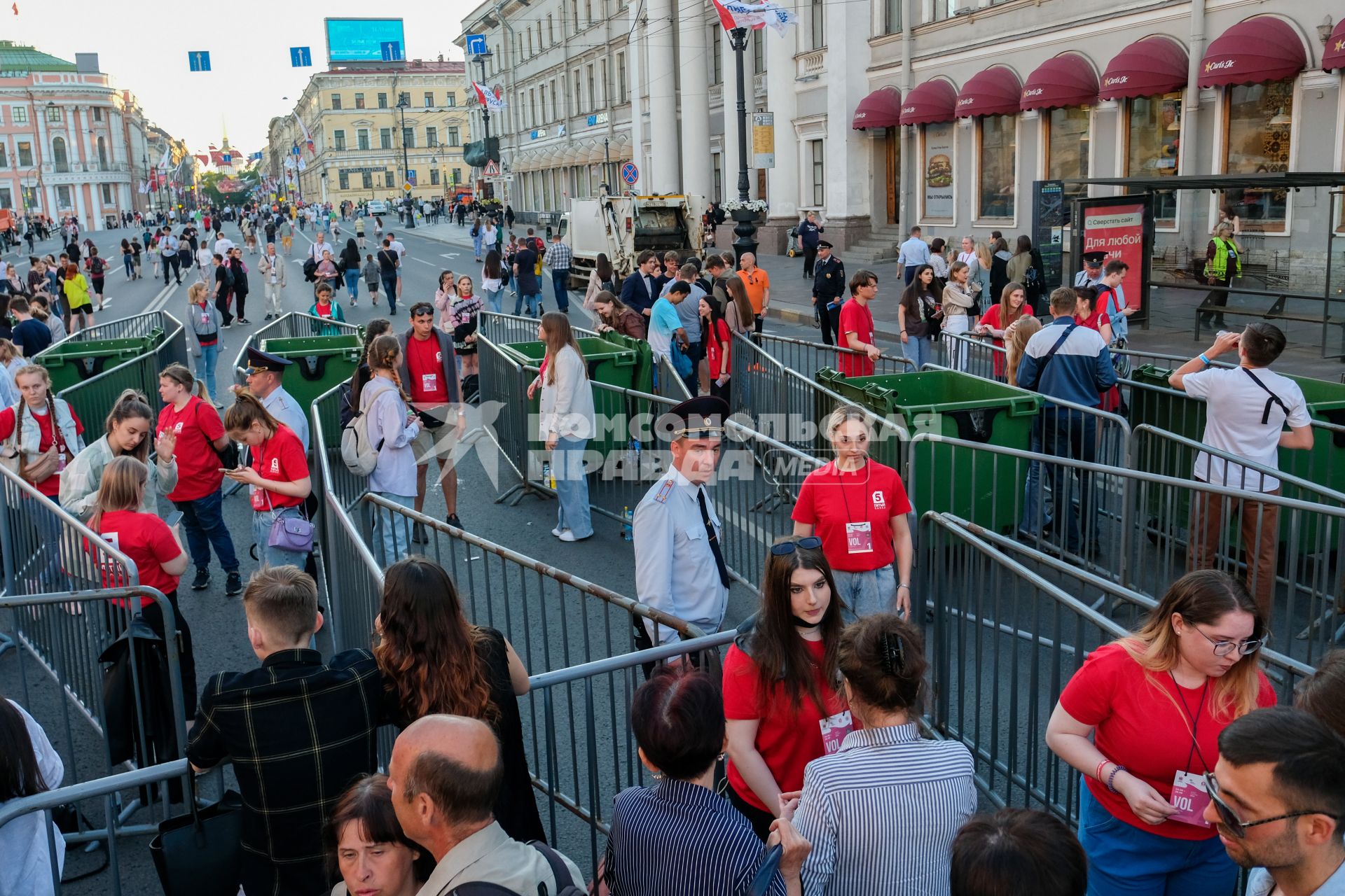 Санкт-Петербург.  Молодые люди проходят через ограждения во время  праздника выпускников `Алые паруса`.