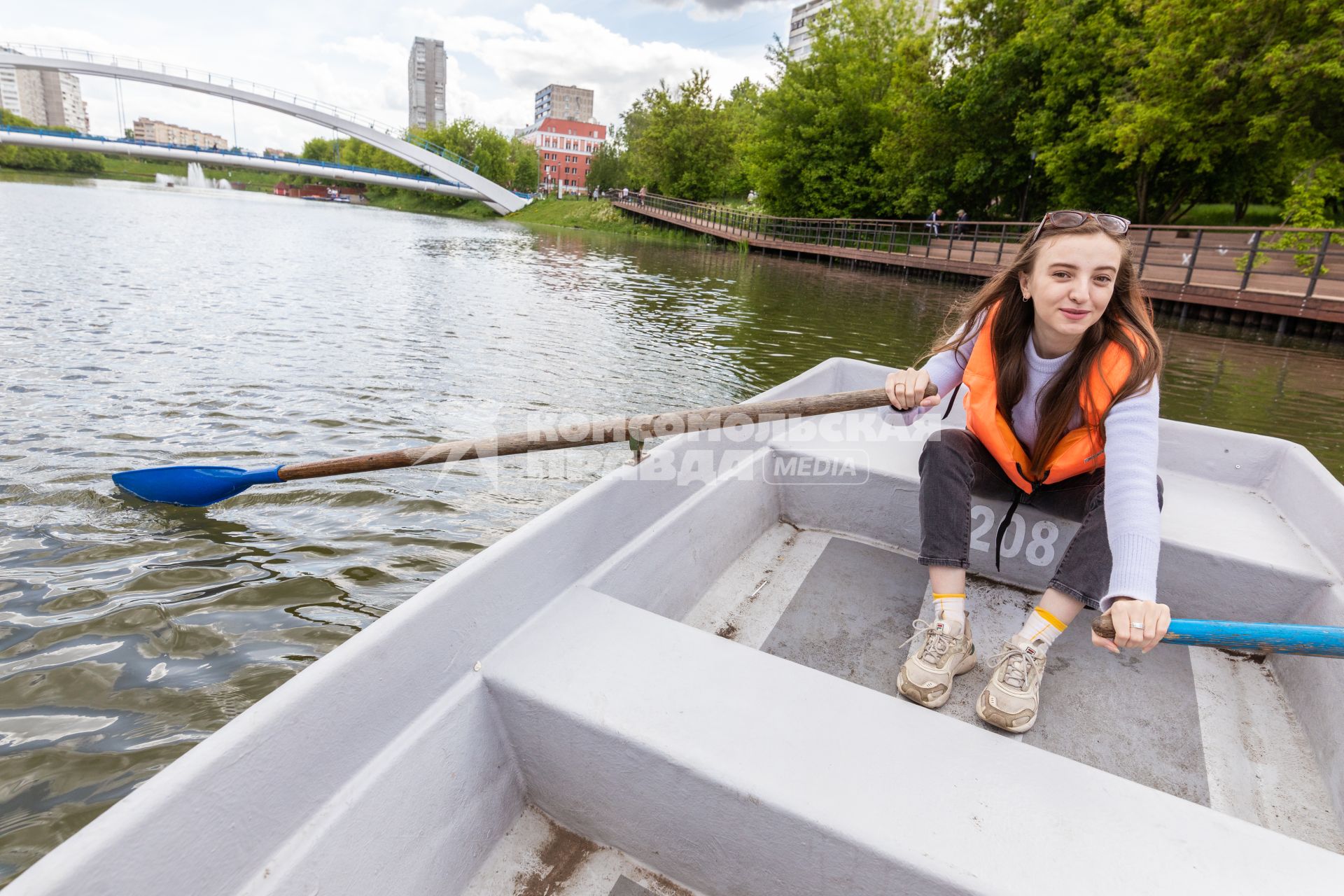 Москва.  Девушка катается в лодке на прудах в   Черкизовском детском парке.