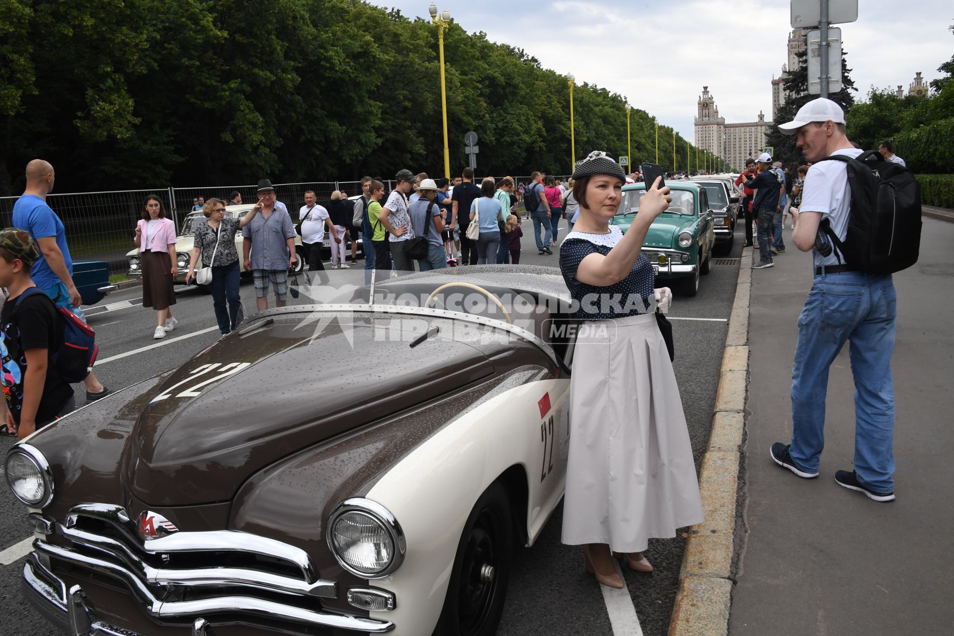 Москва. Женщина фотографируется у ретроавтомобиля  на Воробьевых горах во время фестиваля `Ретрорейс` в рамках празднования Дня московского транспорта.