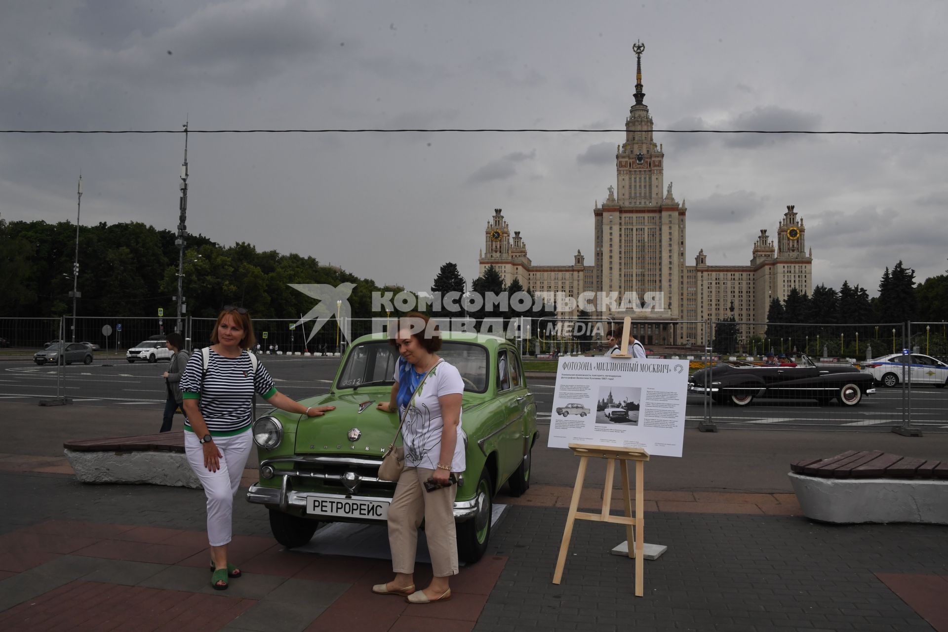 Москва.  Девушки фотографируются у ретроавтомобиля `Москвич `на Воробьевых горах во время фестиваля `Ретрорейс` в рамках празднования Дня московского транспорта.