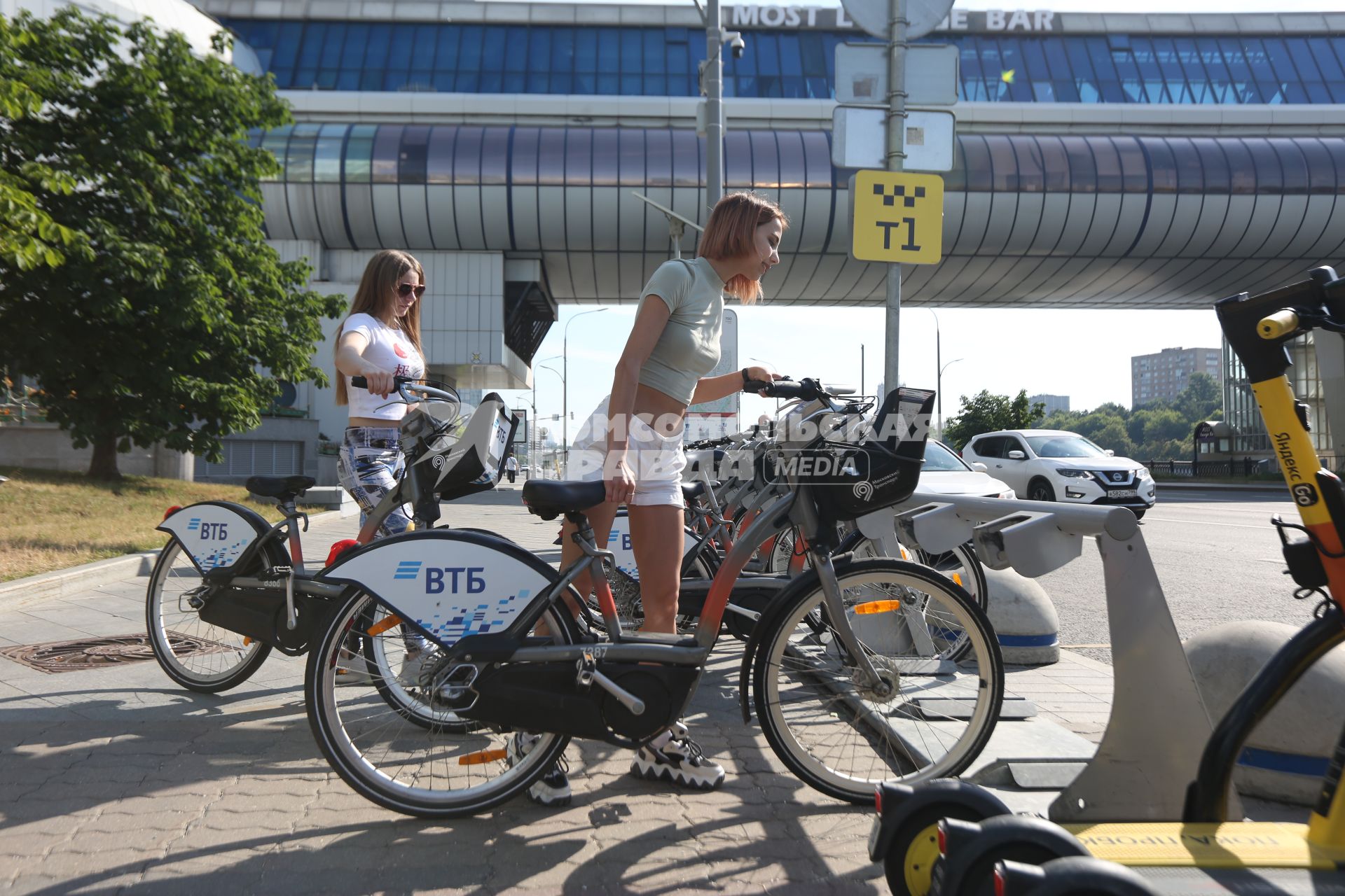 Москва. Девушка берет велосипед в городском общественном  прокате велосипедов.