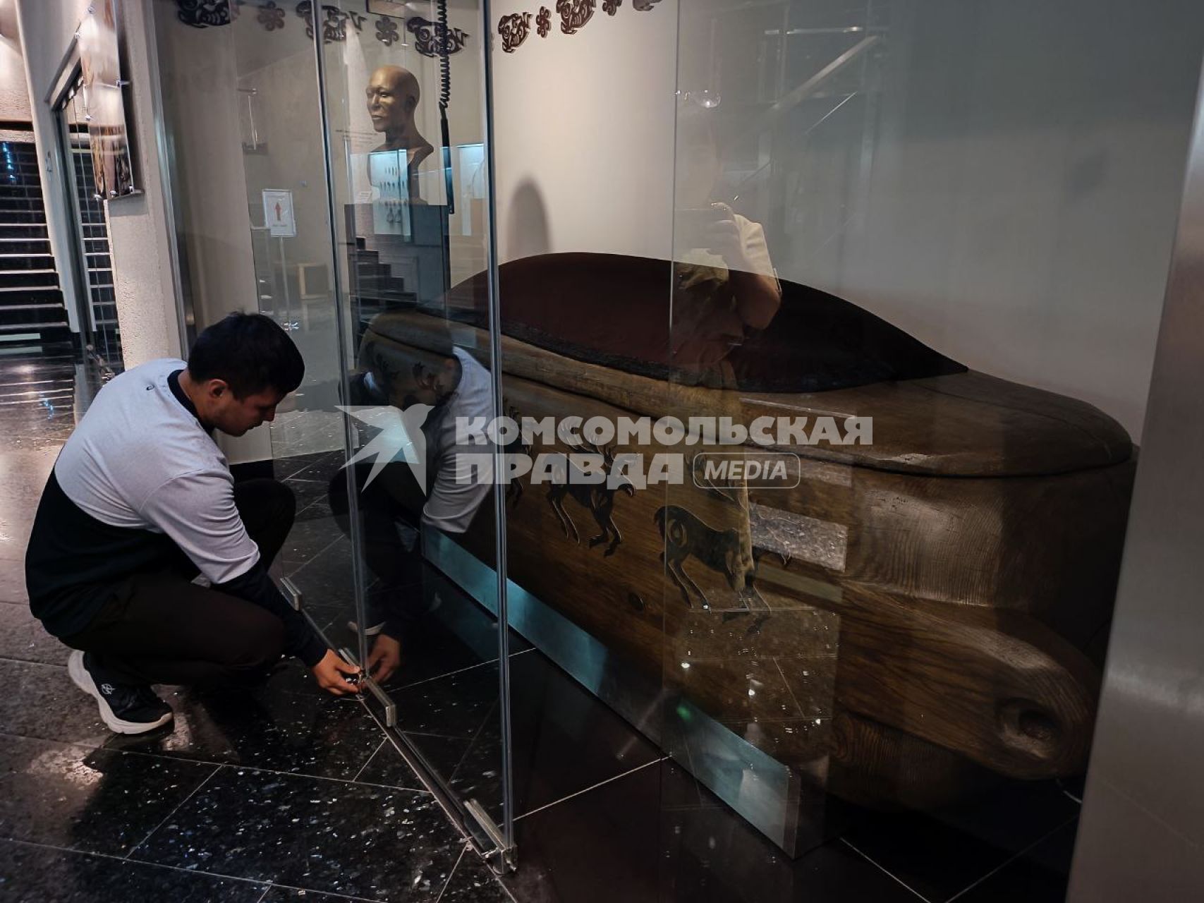 Новосибирск.  Сотрудник  музея показывает гроб в котором была погребена  принцессы Укоки в   музее в Горно-Алтайске.
