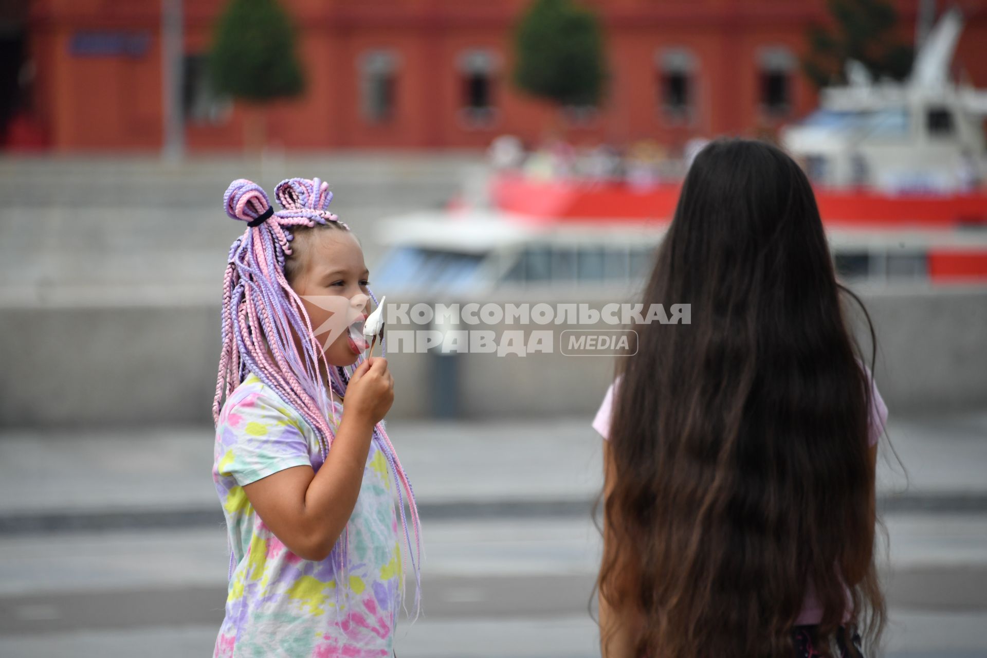 Москва. Девочки едят мороженое  в жаркую погоду   в Парке искусств Музеон .