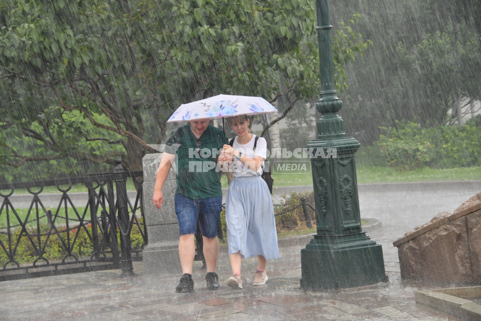 Москва.  Прохожие в Александровском саду во время дождя.