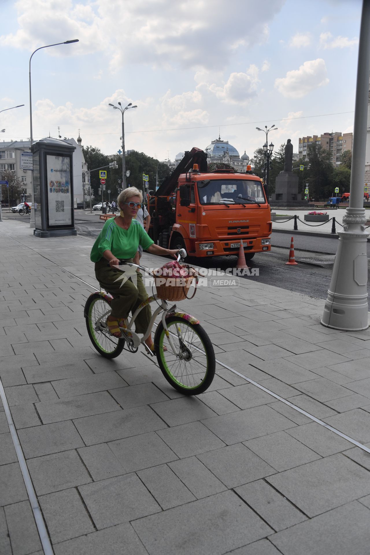 Москва.  Женщина едет на велосипеде.