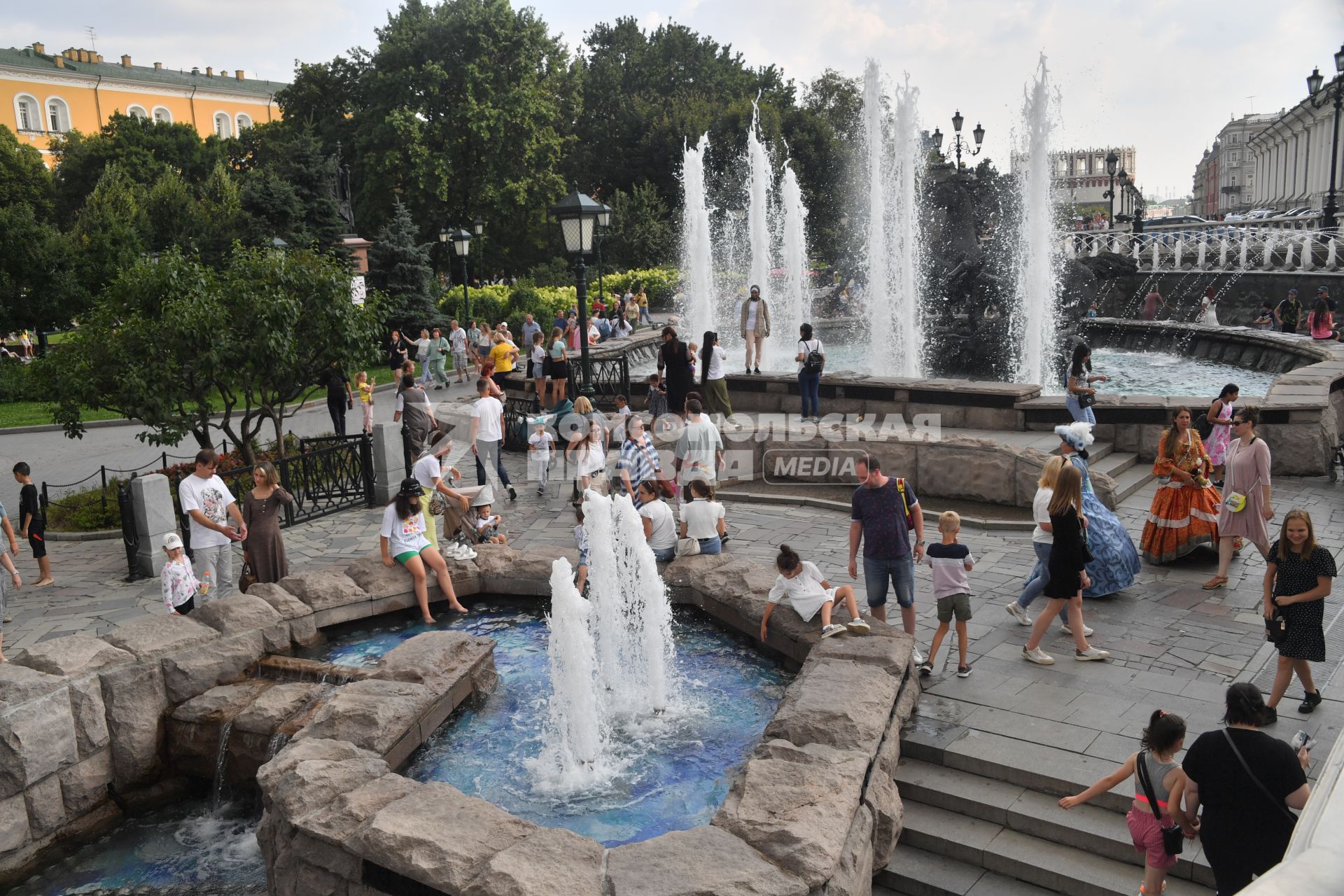 Москва.  Люди у фонтанов на Манежной полщади.