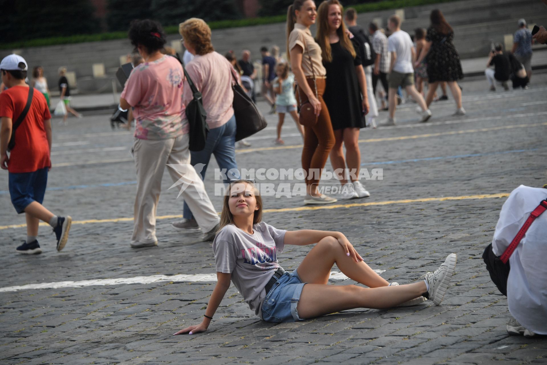 Москва.  Девушка сидит на брусчатке Красной площади.