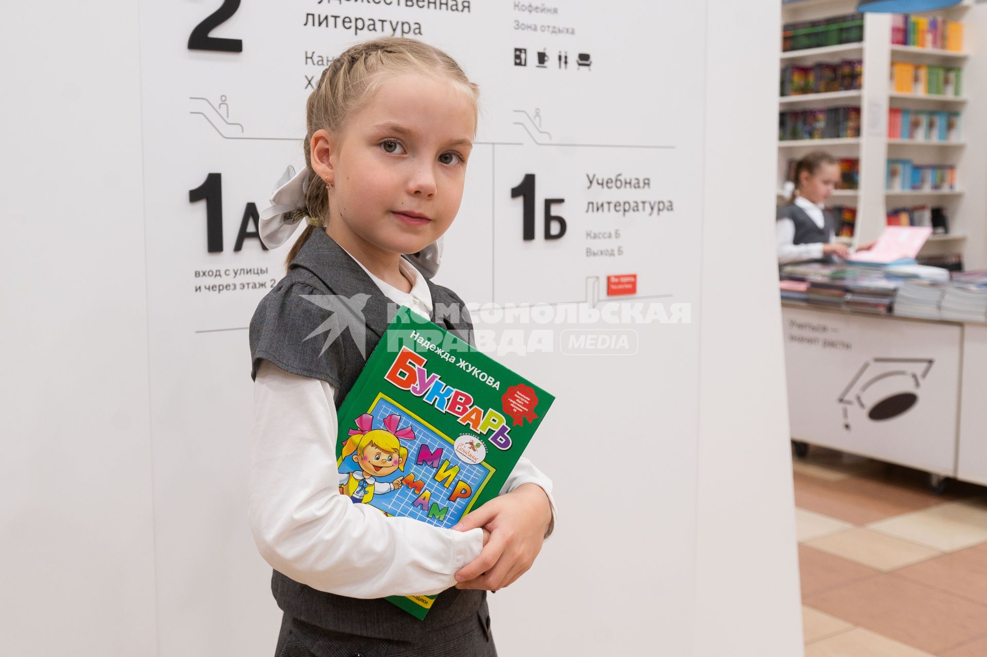 Санкт-Петербург. Девочка с букварем в отделе школьных принадлежностей в магазине перед началом учебного года.