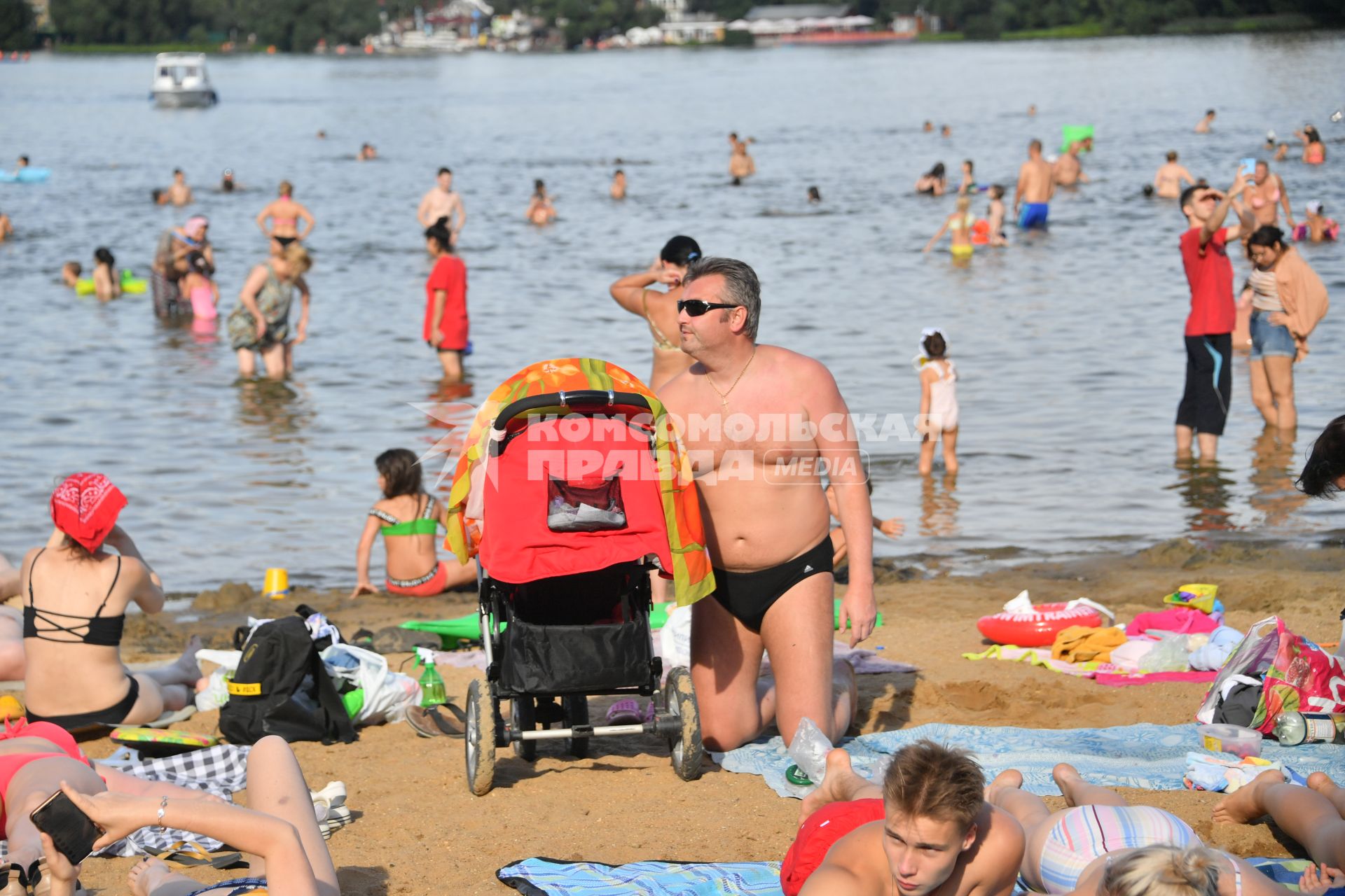 Москва. Люди загорают на пляже Косинского озера.