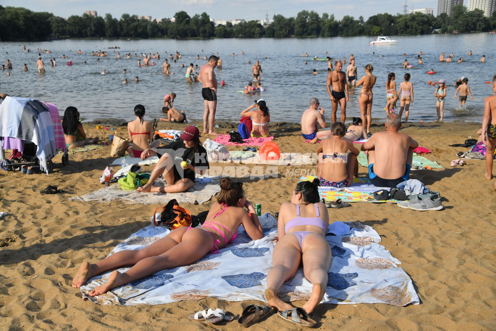 Москва. Люди загорают на пляже Косинского озера.