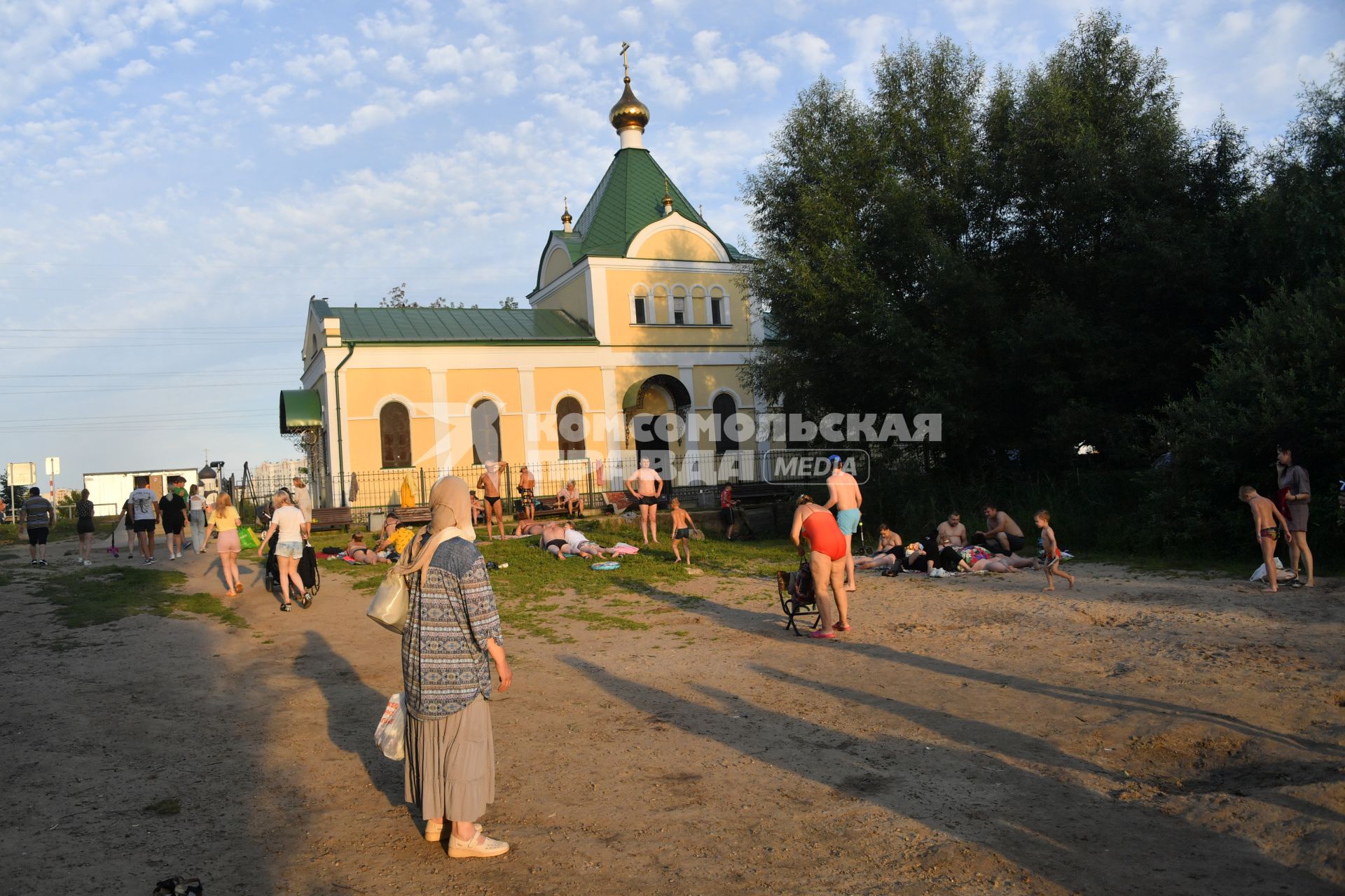 Москва. Природно-исторический парк `Косинский`. Люди загорают у храма Успения Пресвятой Богородицы у Святого озера.