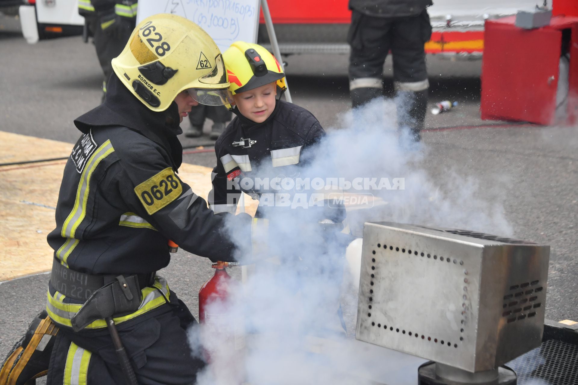 Москва. Мальчик вмести с пожарным тушат огонь в рамках III Международного пожарно-спасательного конгресса на территории Парка Горького.