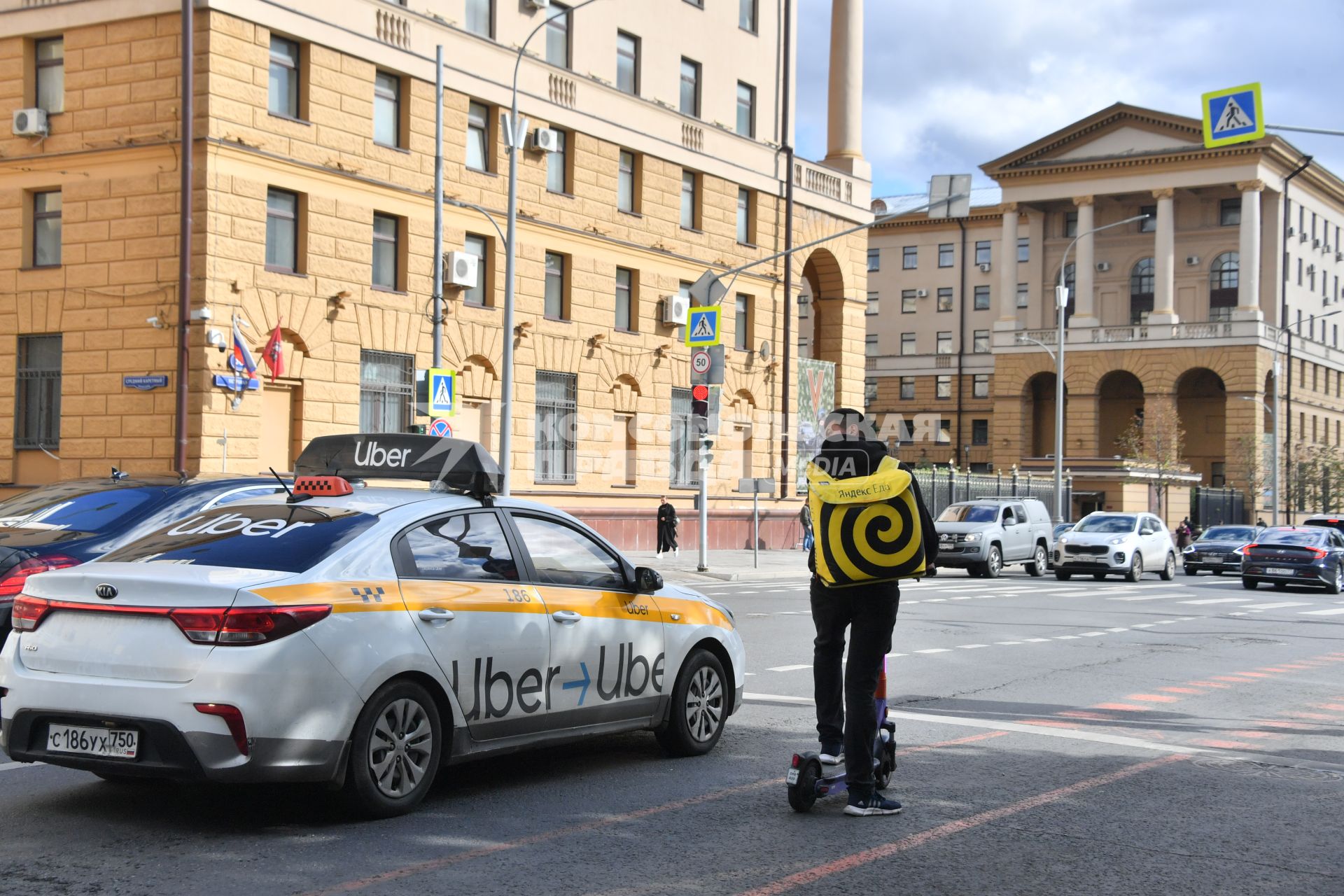 Москва.  Сотрудник службы доставки еды на улице города.