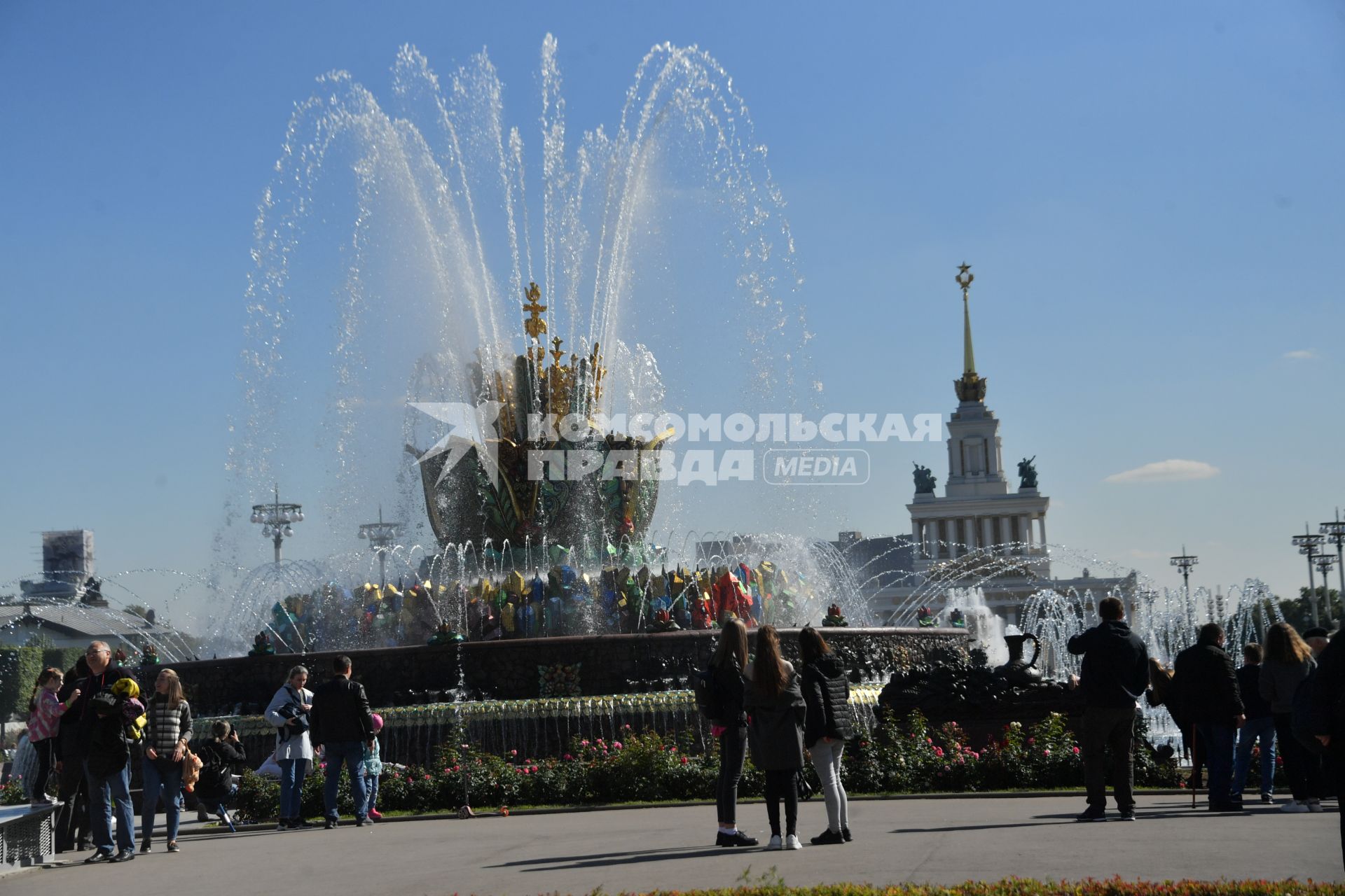 Москва.  Люди гуляют у фонтана   `Каменный цветок` на ВДНХ во время празднования Дня города.