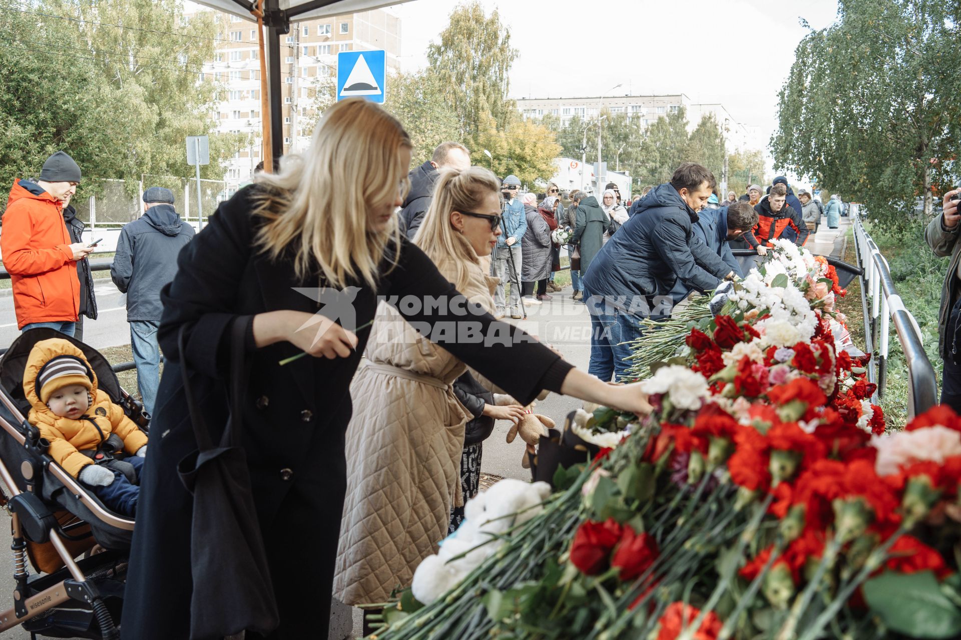 Ижевск. Люди приносят цветы к стихийному мемориалу у школы #88, где 26 сентября 2022 г. в результате стрельбы погибли 17 человек.