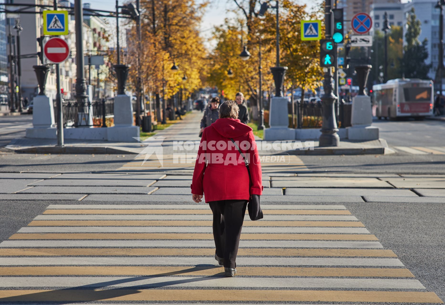 Пермь. Женщина переходит дорогу по пешеходному переходу.