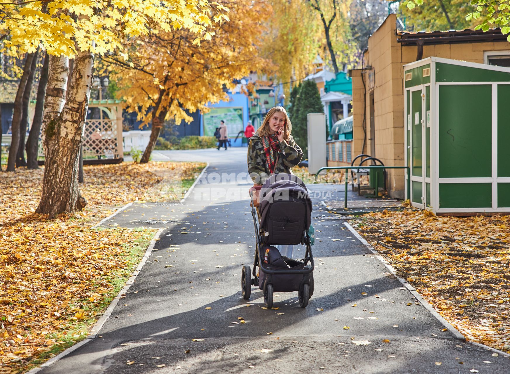 Пермь. Девушка гуляет с детской коляской в осеннем парке