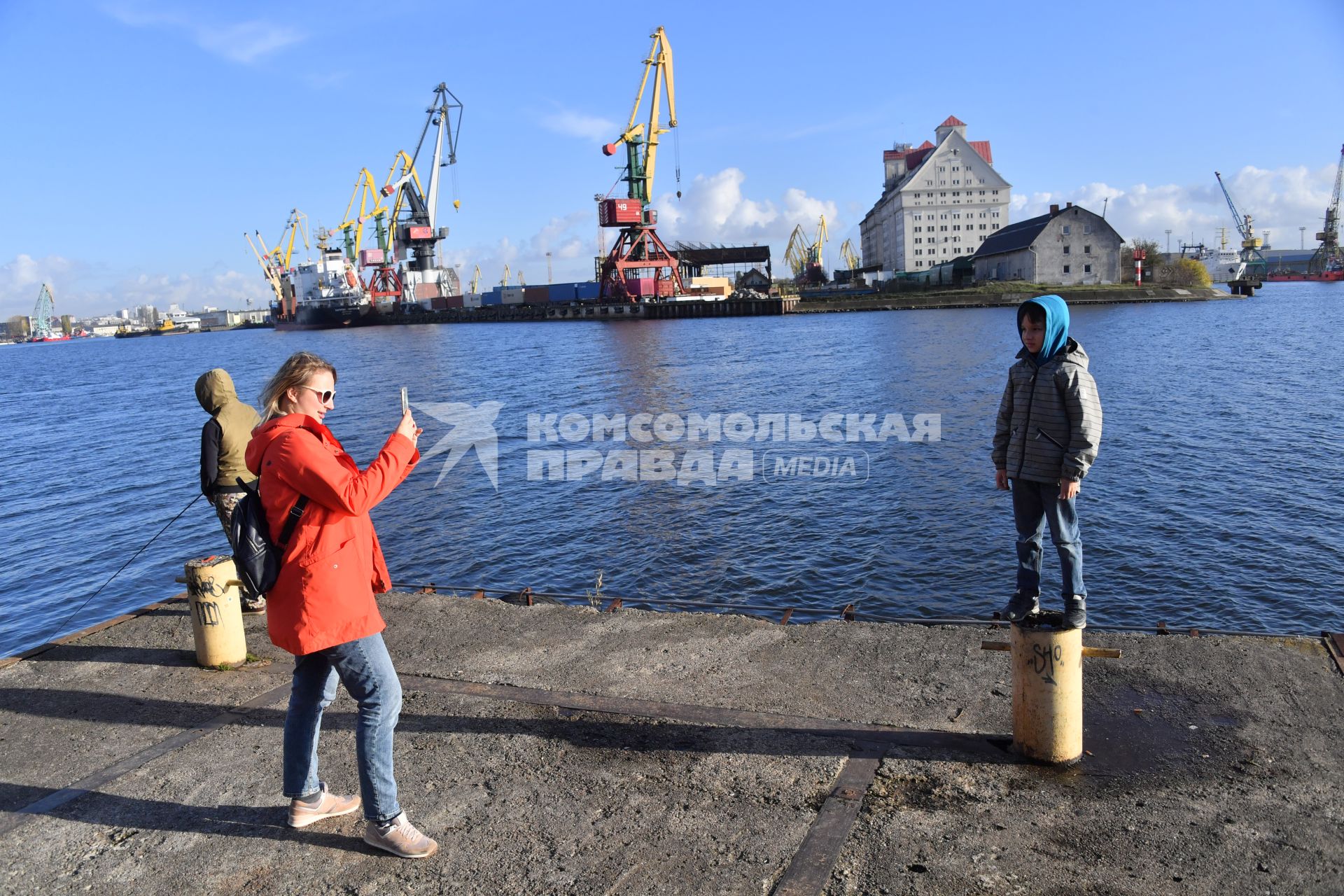 Калининград. Женщтна фотографирует мальчика на городской набережной.