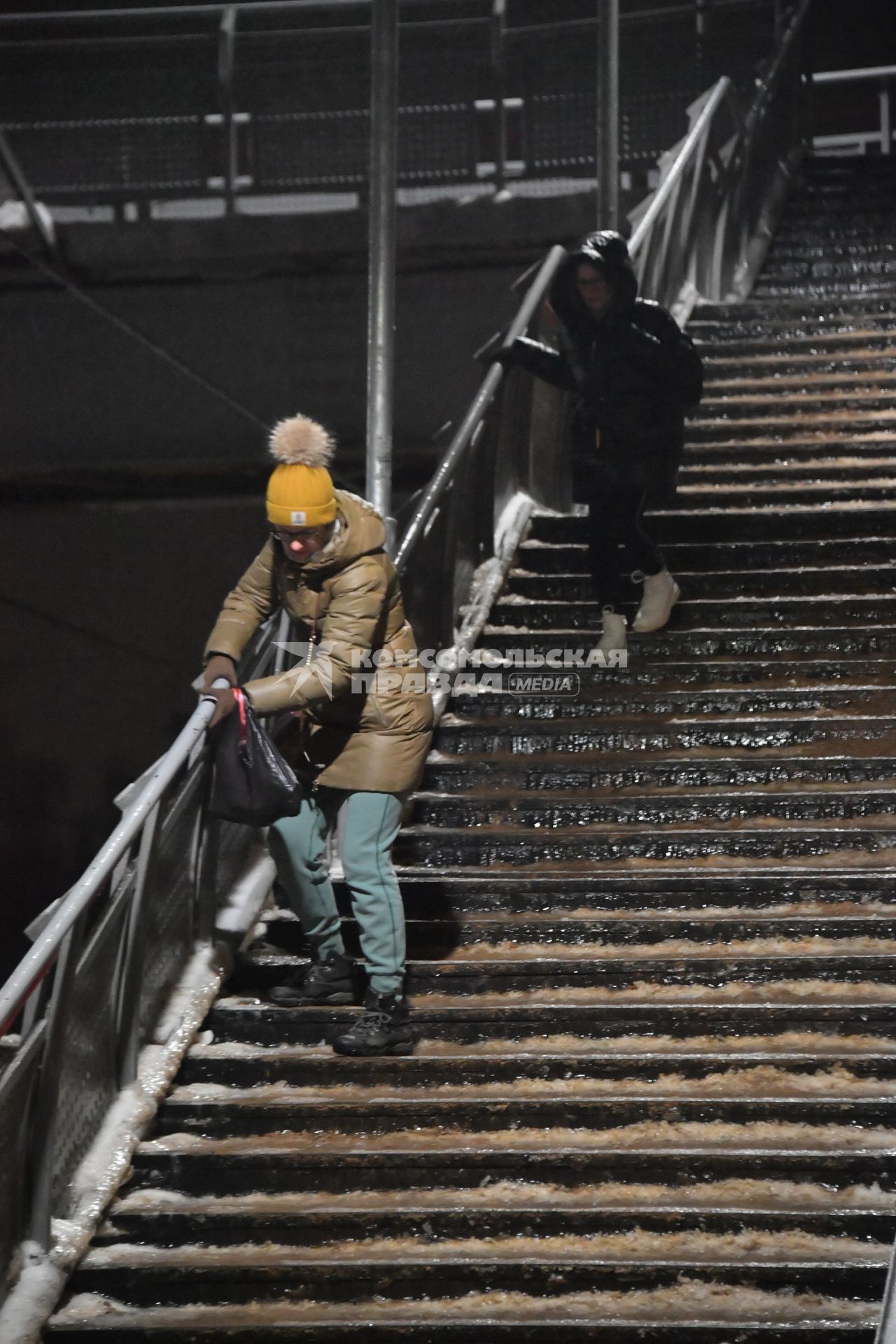 Москва. Люди спускаются по лестнице во время ледяного дождя на железнодорожном вокзале.