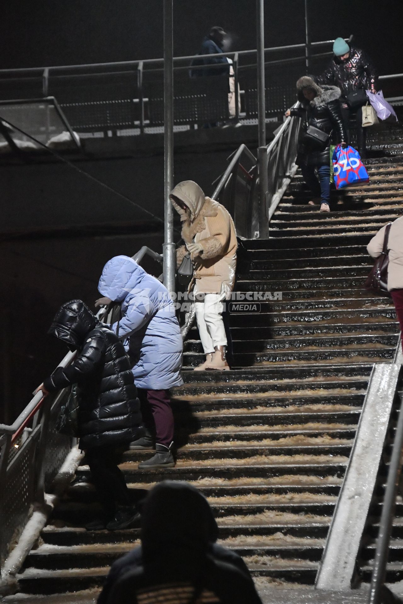 Москва. Люди спускаются по лестнице во время ледяного дождя на железнодорожном вокзале.