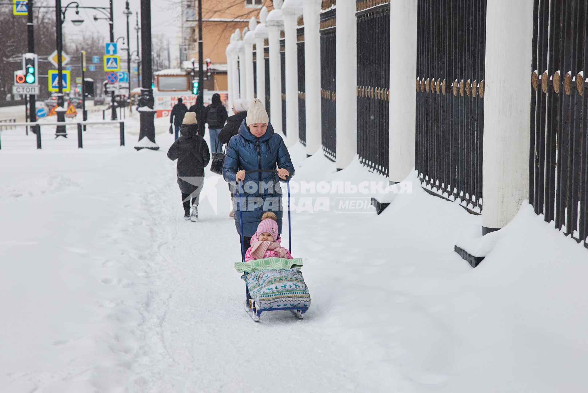 Пермь. Женщина везет ребенка на санках.