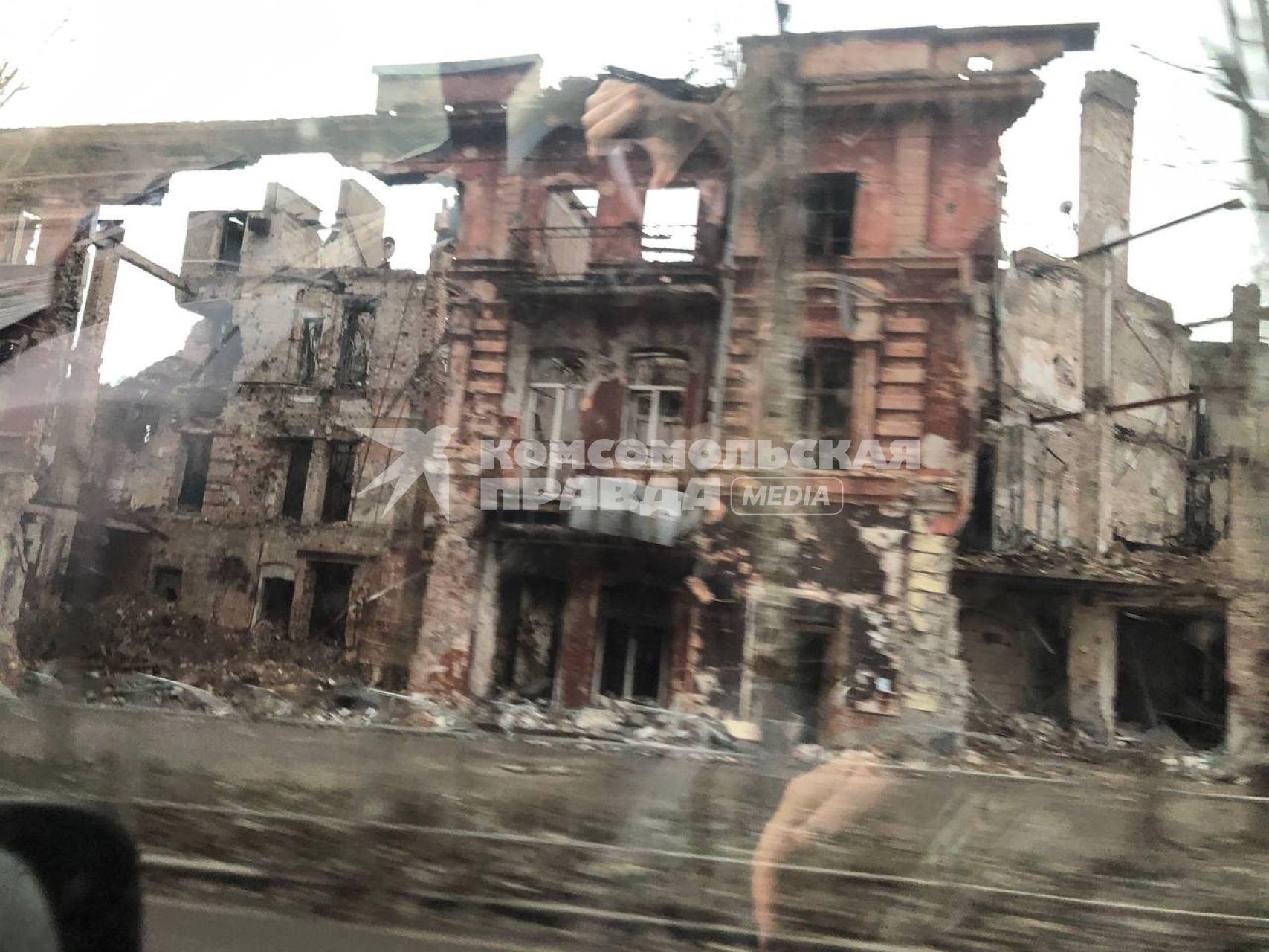 Донецкая область. г. Мариуполь. Вид из окна машины на разрушенный дом.