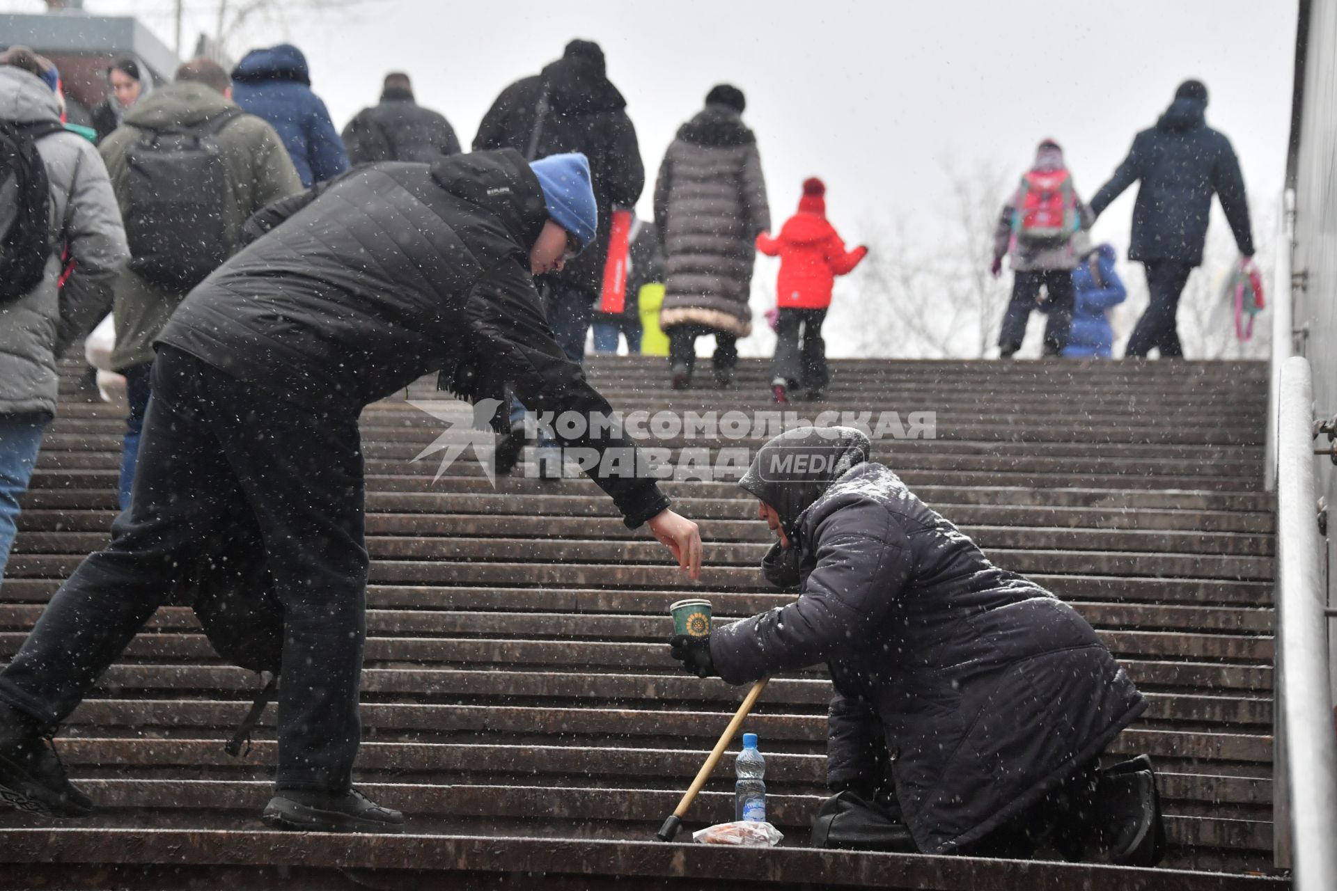 Москва. Пожилая женщина просит милостыню у подземного перехода.