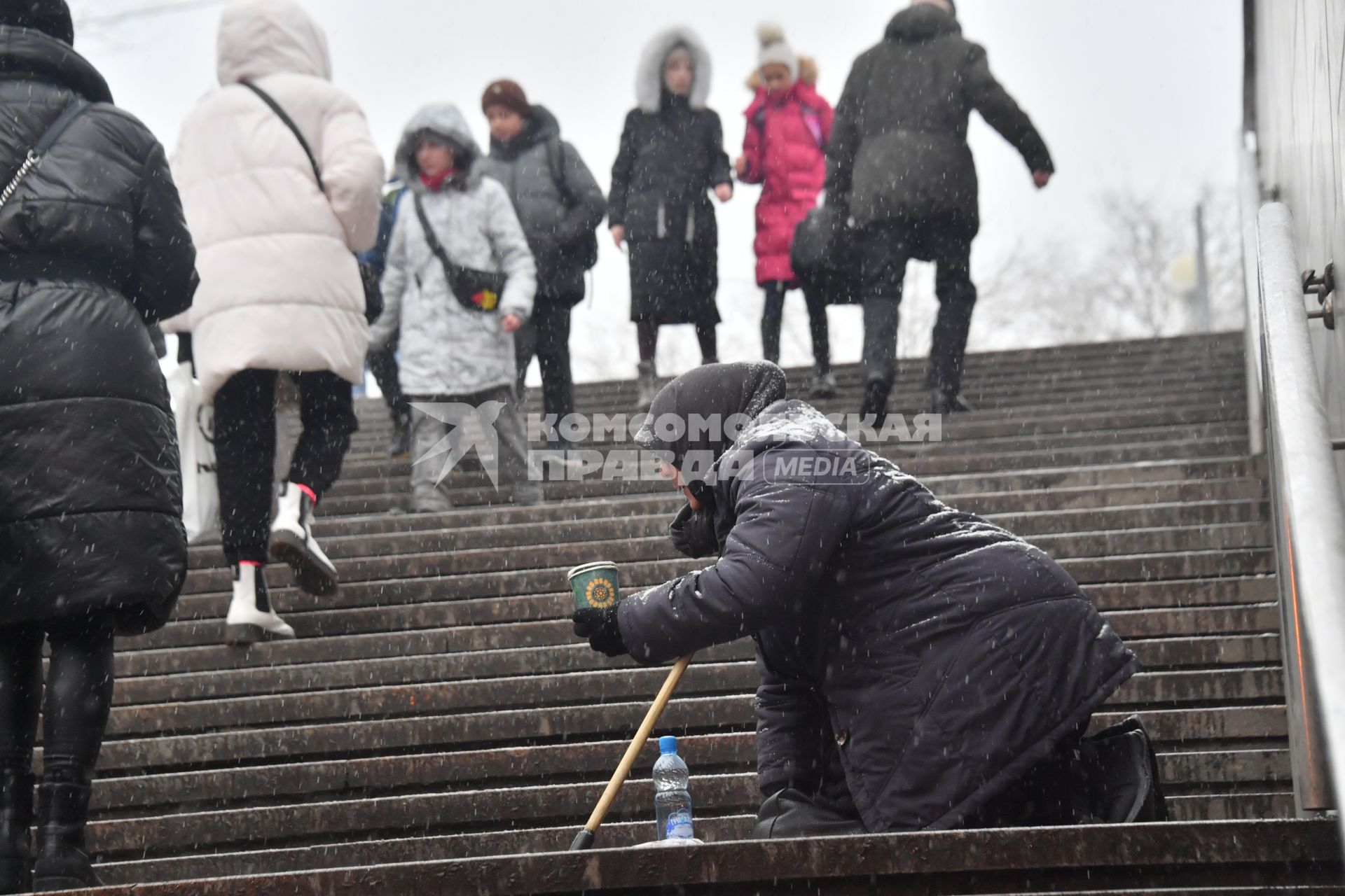 Москва. Пожилая женщина просит милостыню у подземного перехода.