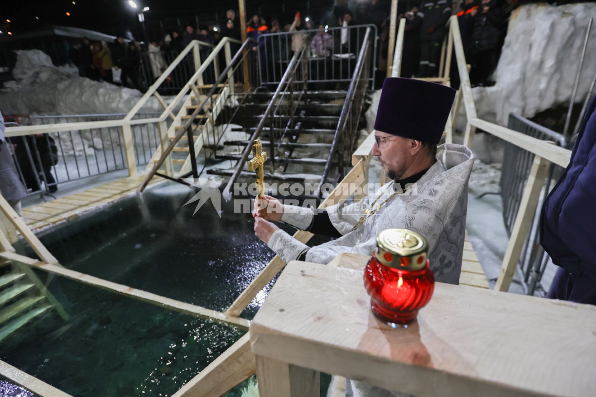 Владивосток. Батюшка освящает воду в купели перед началом ночных крещенских купаний на пляже Юбилейный.