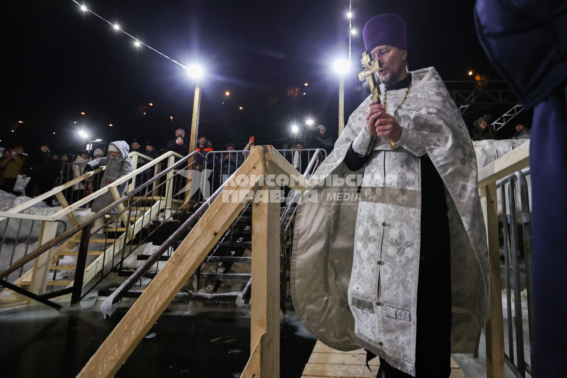 Владивосток. Батюшка освящает воду в купели перед началом ночных крещенских купаний на пляже Юбилейный.