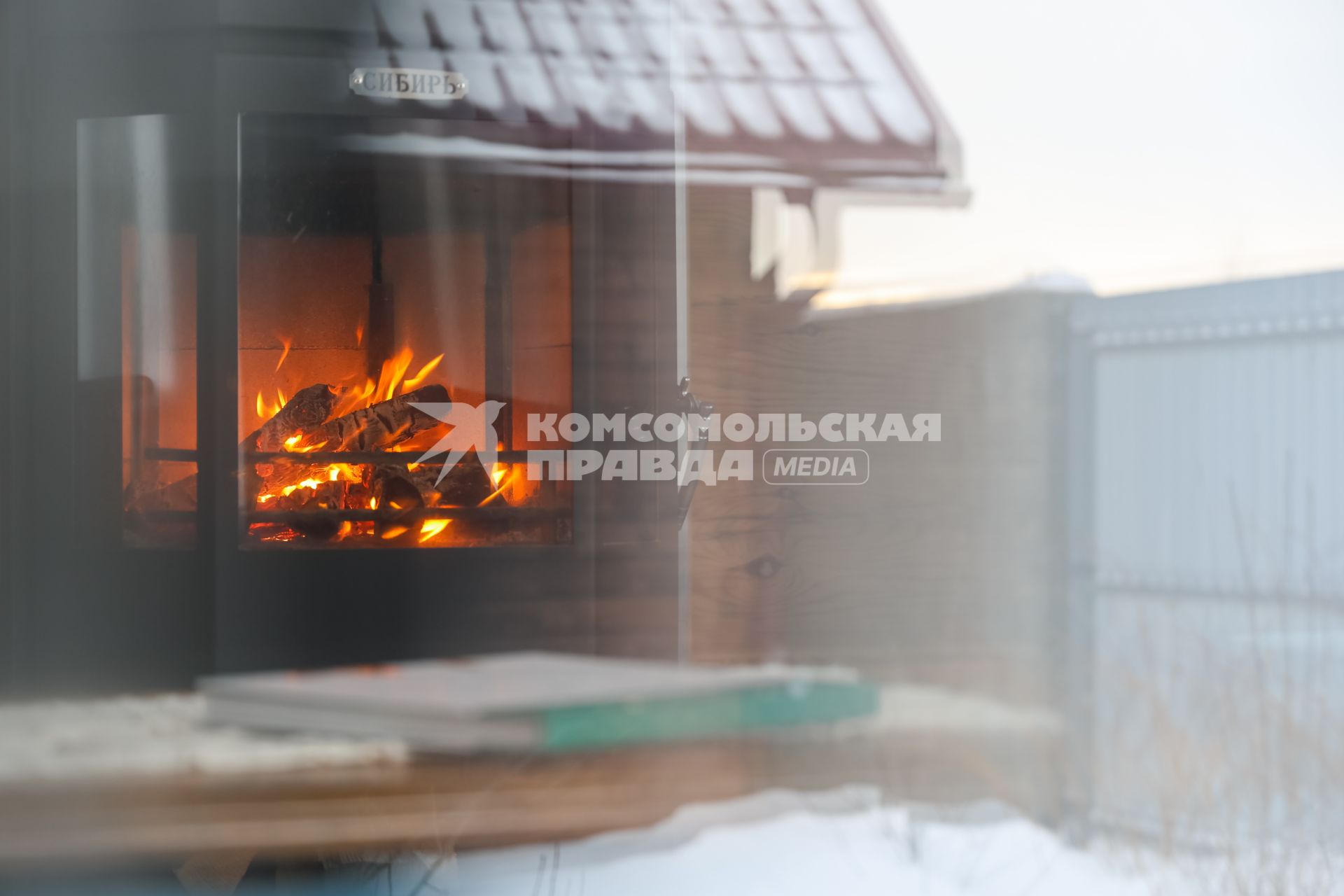 Красноярск. Отражение камина в окне загородного дома.