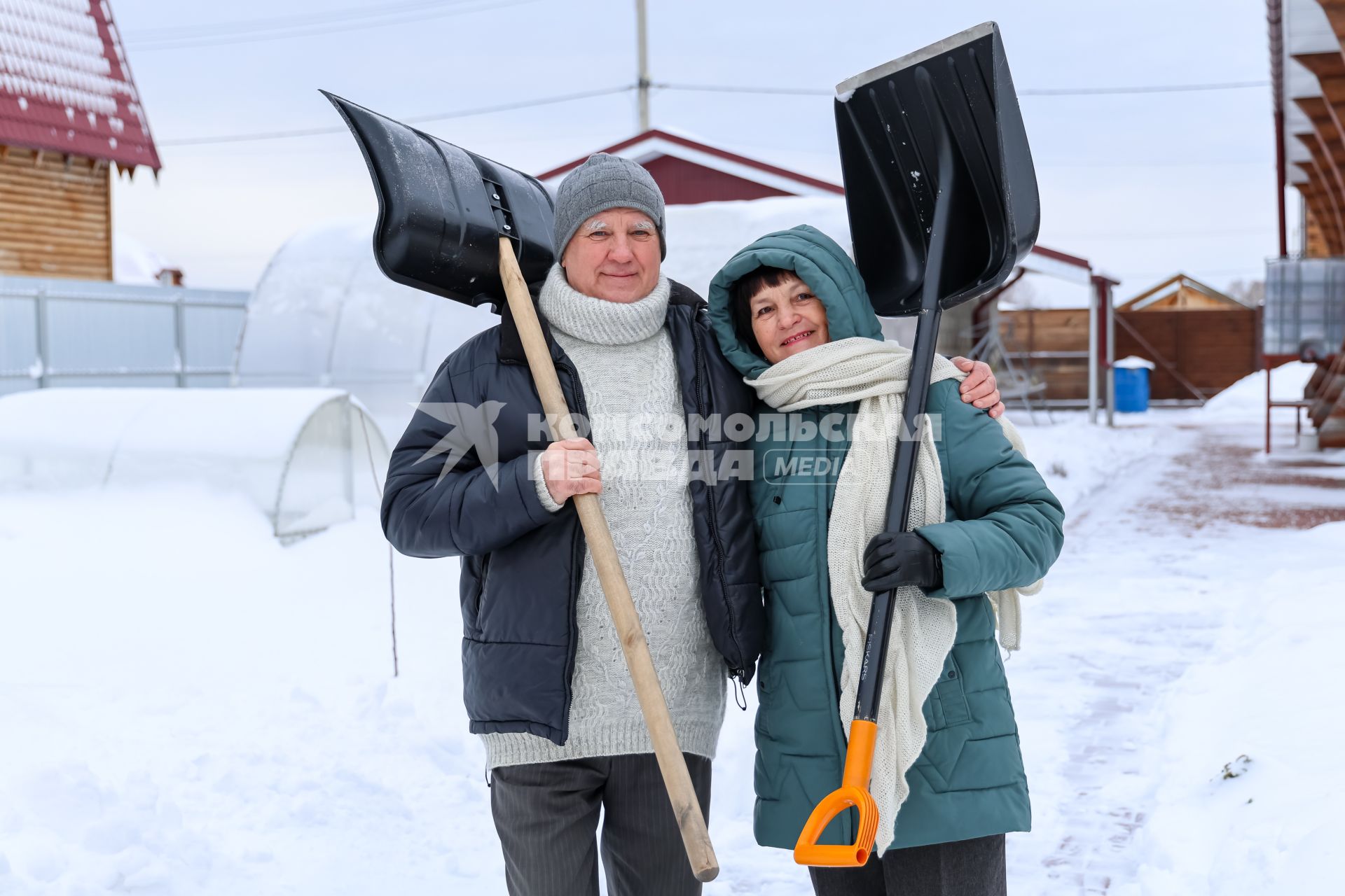 Красноярск. Пожилая пара убирает снег на своем приусадебном участке.