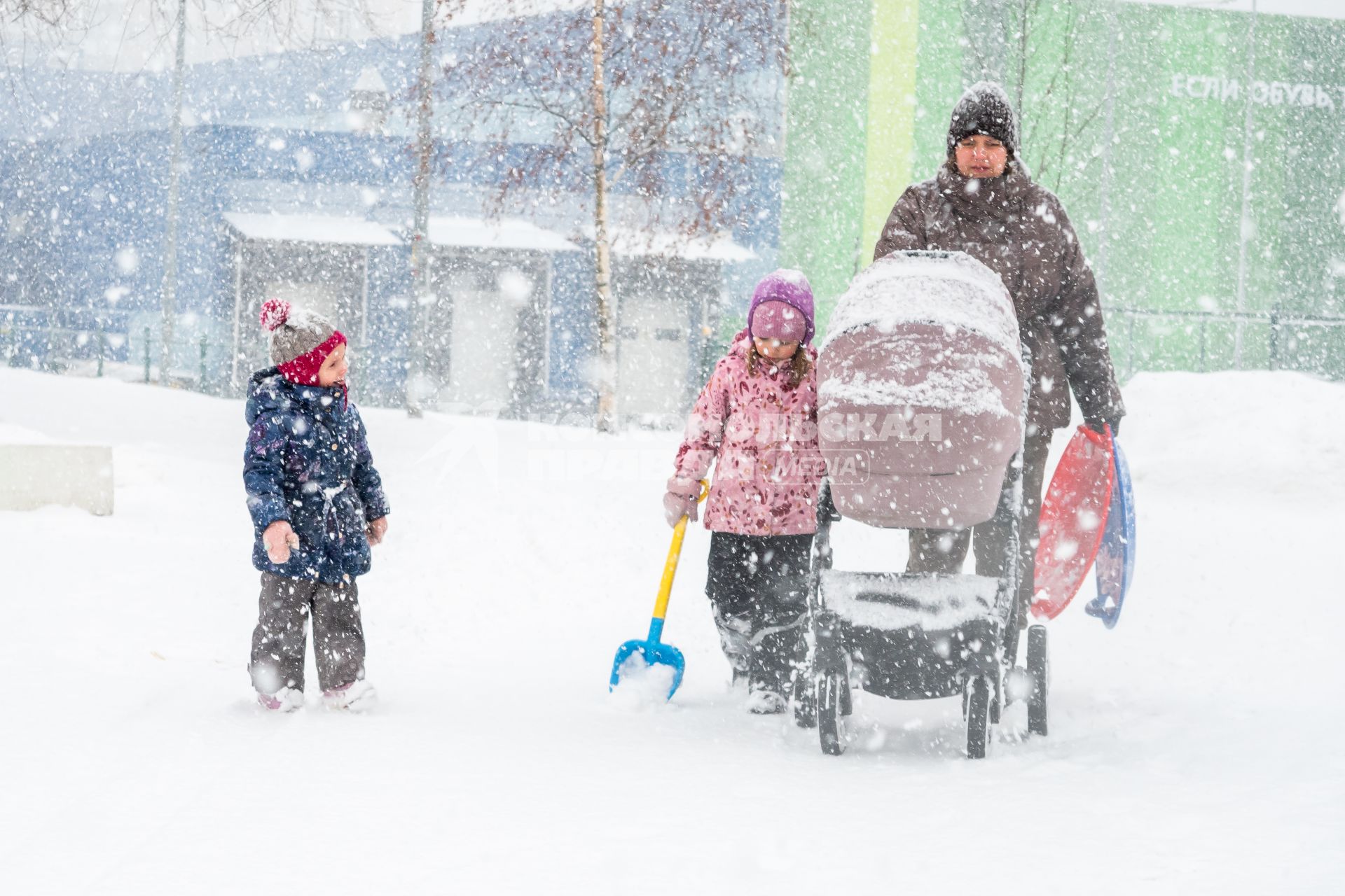 Санкт-Петербург. Женщина с детьми   на улице во время снежного шторма.