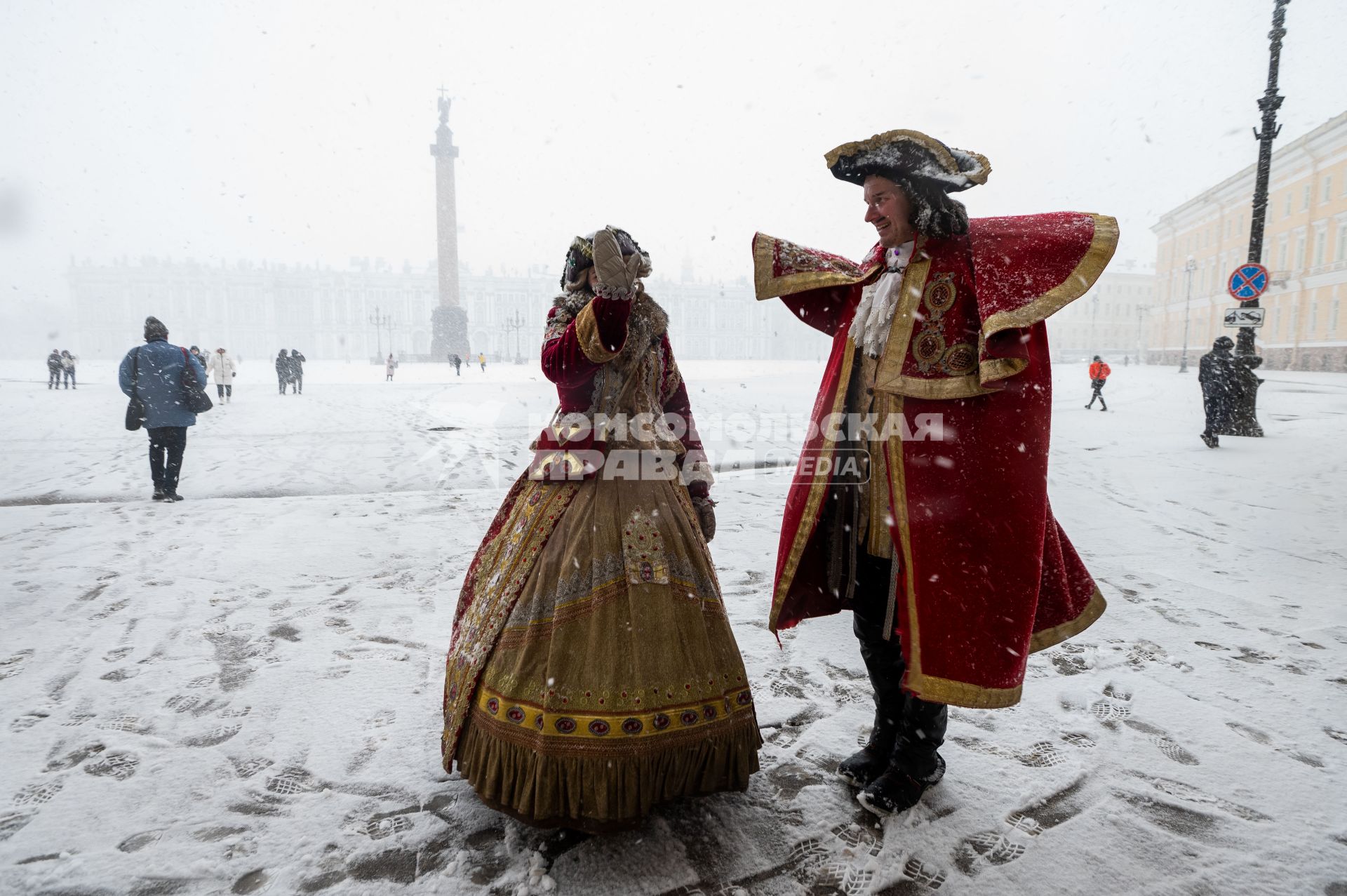 Санкт-Петербург. Мужчина и женщина  в исторических костюмах на Дворцовой площади во время снежного шторма.