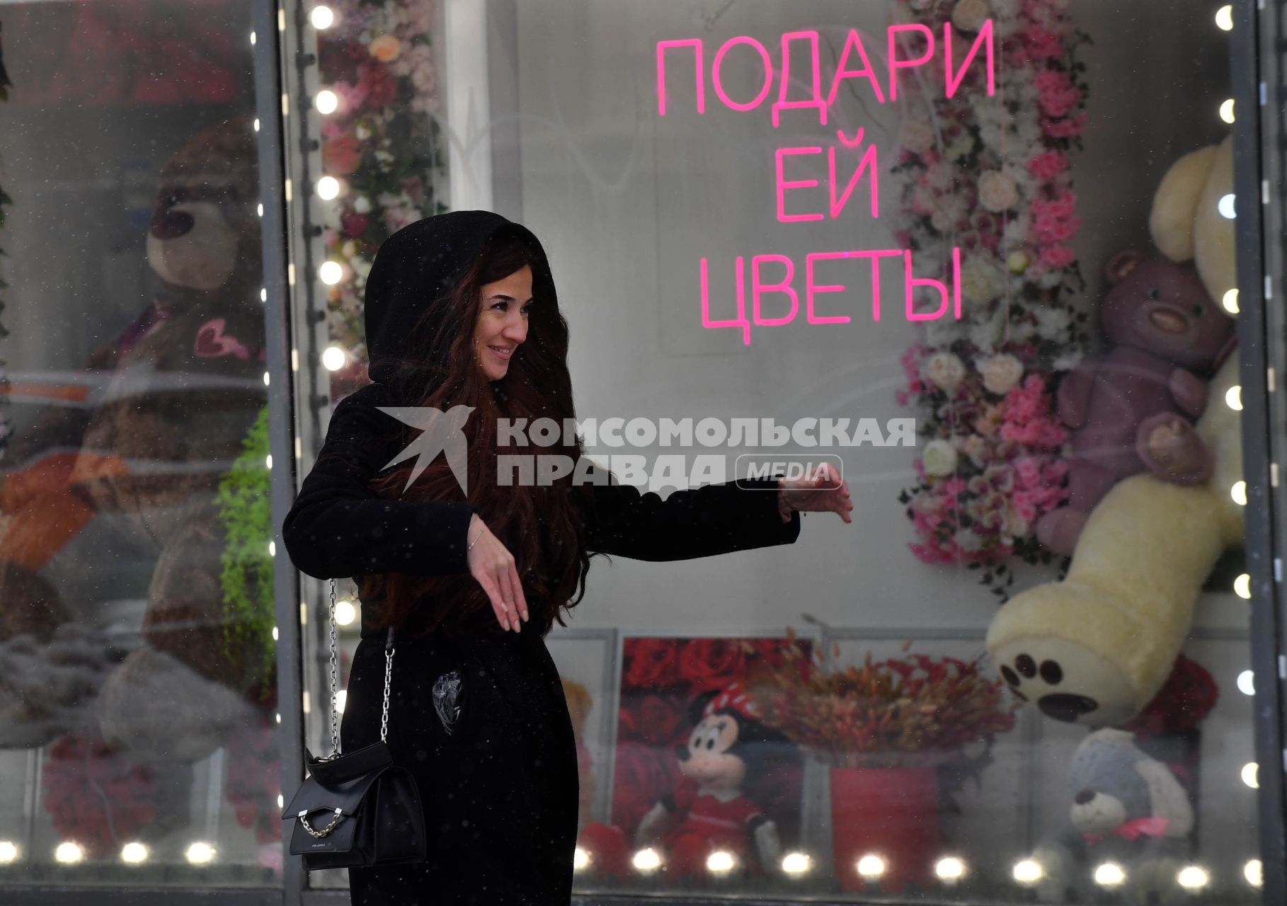 Москва. Девушка у  витрины магазина  в международный женский день 8 Марта.