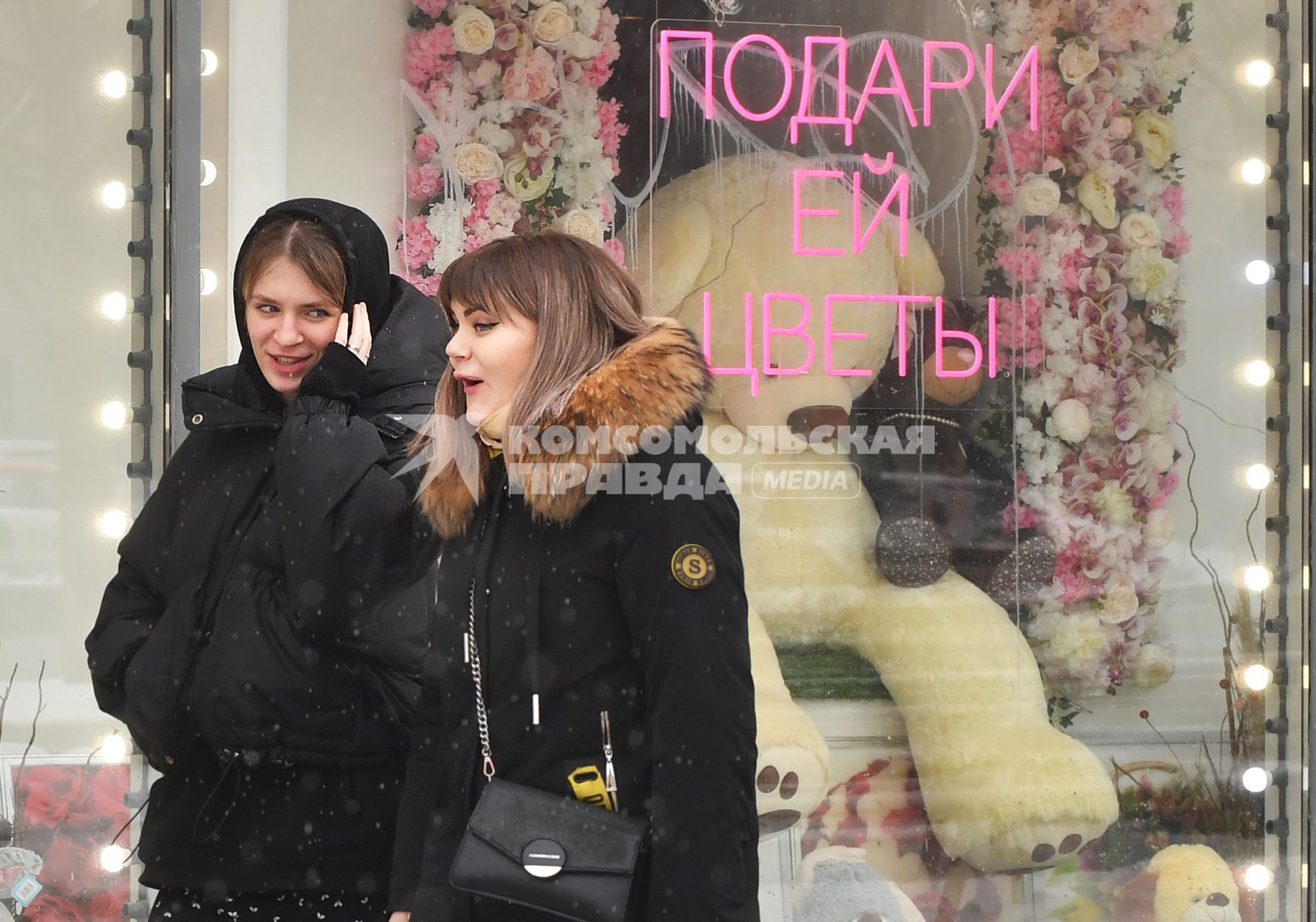 Москва. Девушки у  витрины магазина  в международный женский день 8 Марта.