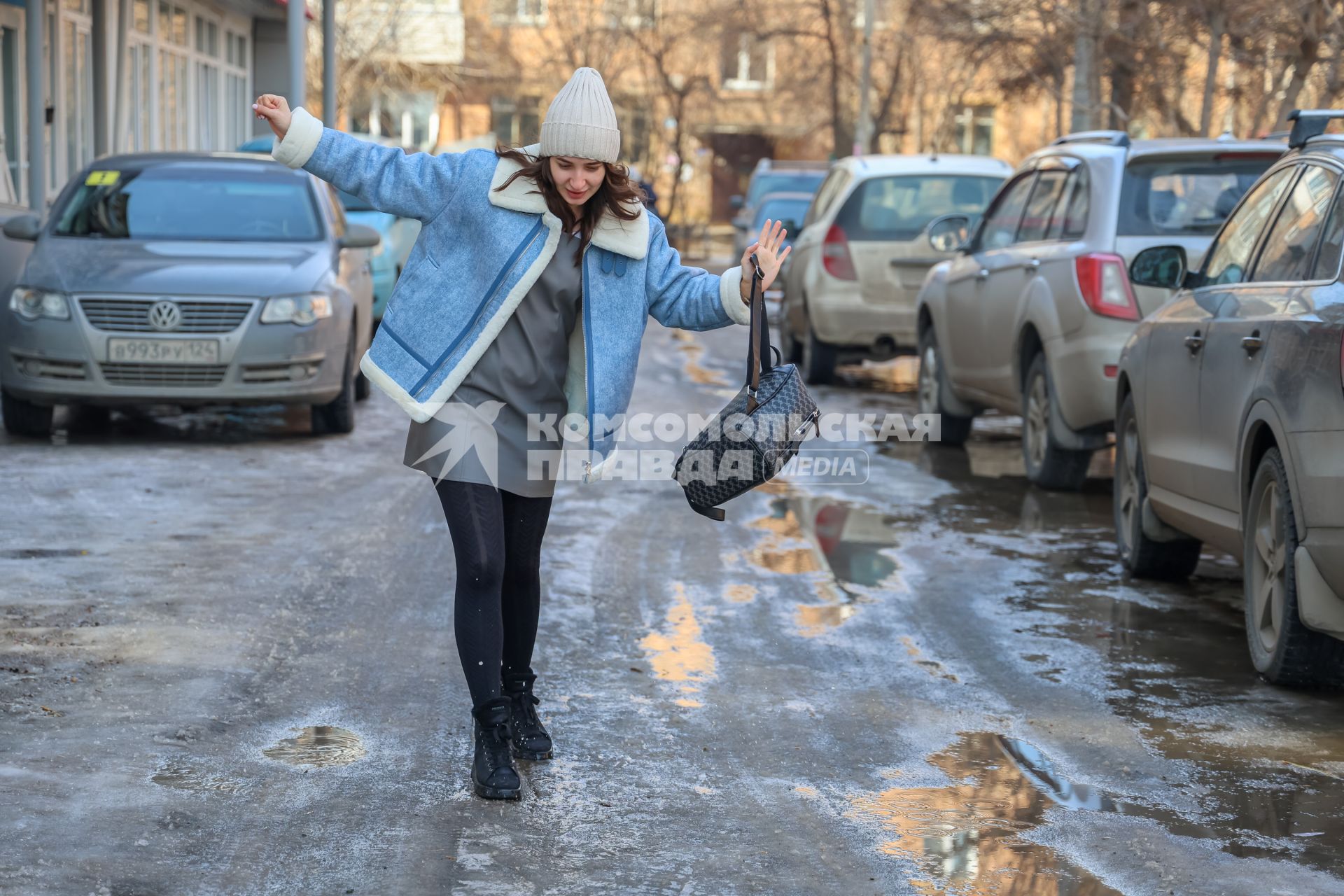 Красноярск. Девушка идет по дороге во время гололеда.