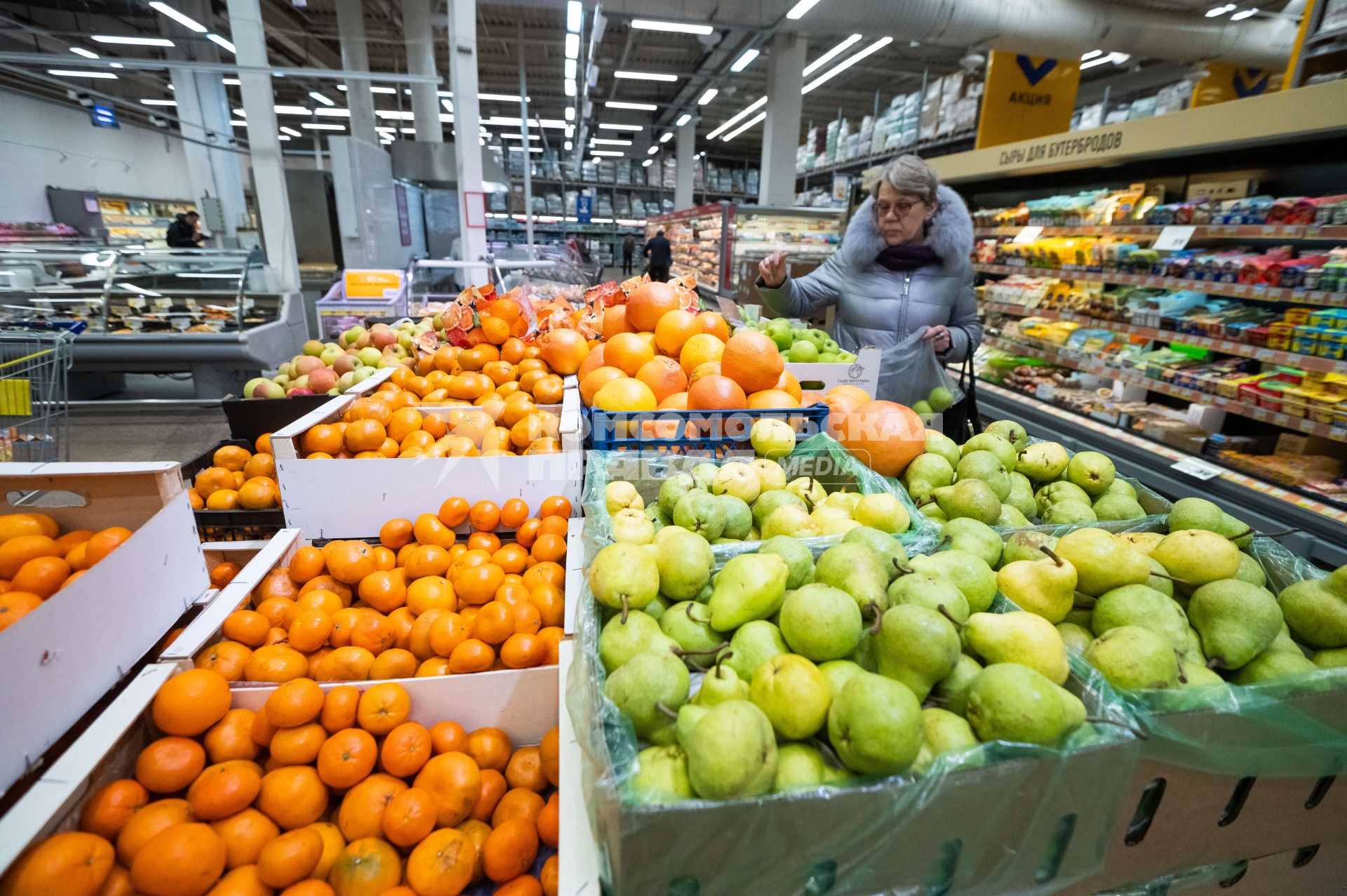 Санкт-Петербург. Женщина выбирает фрукты в супермаркете.