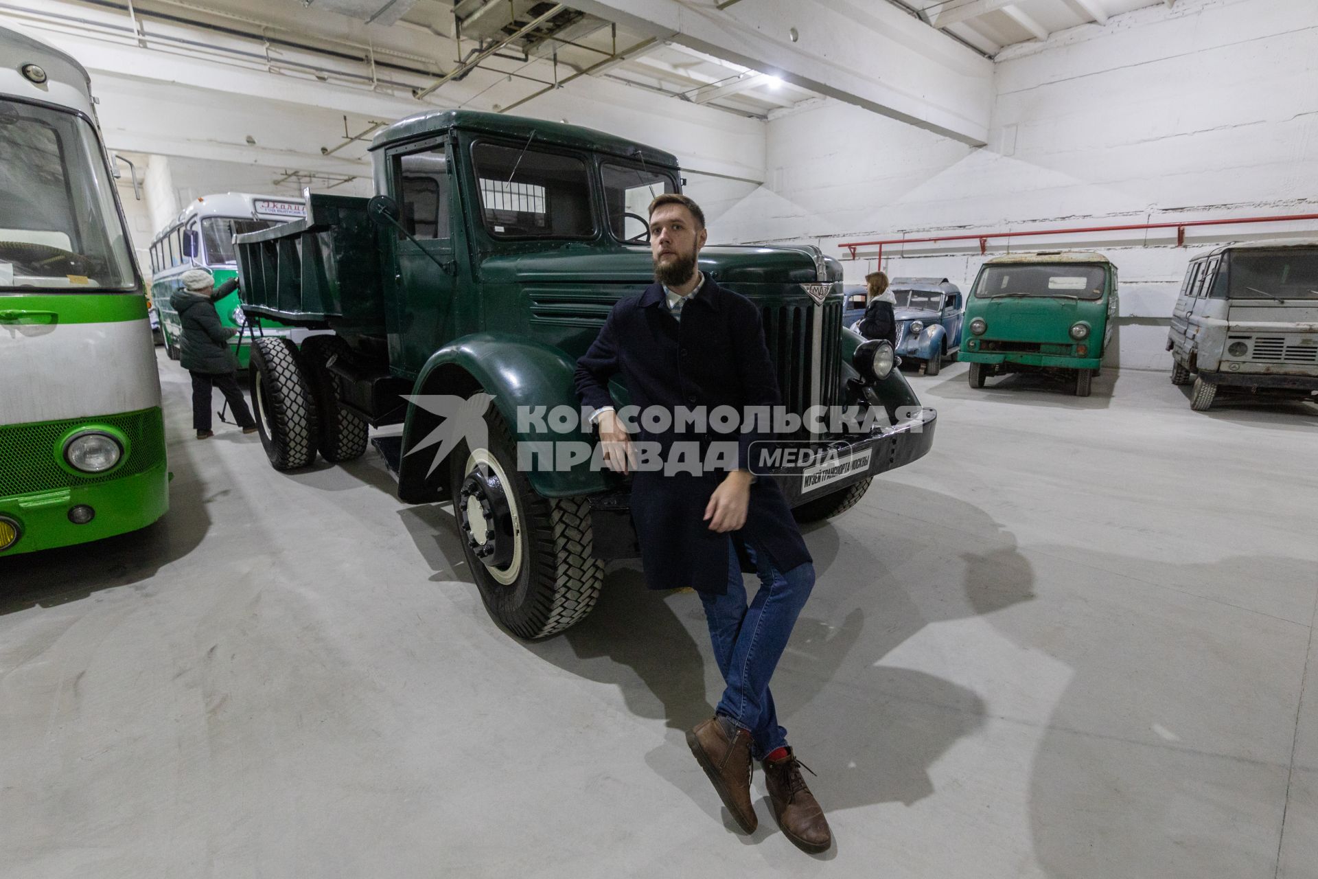 Москва. Корреспондент `Комсомольской правды`Андрей Абрамов у автомобиля МАЗ-205А в фонде хранения коллекции Музея транспорта Москвы.