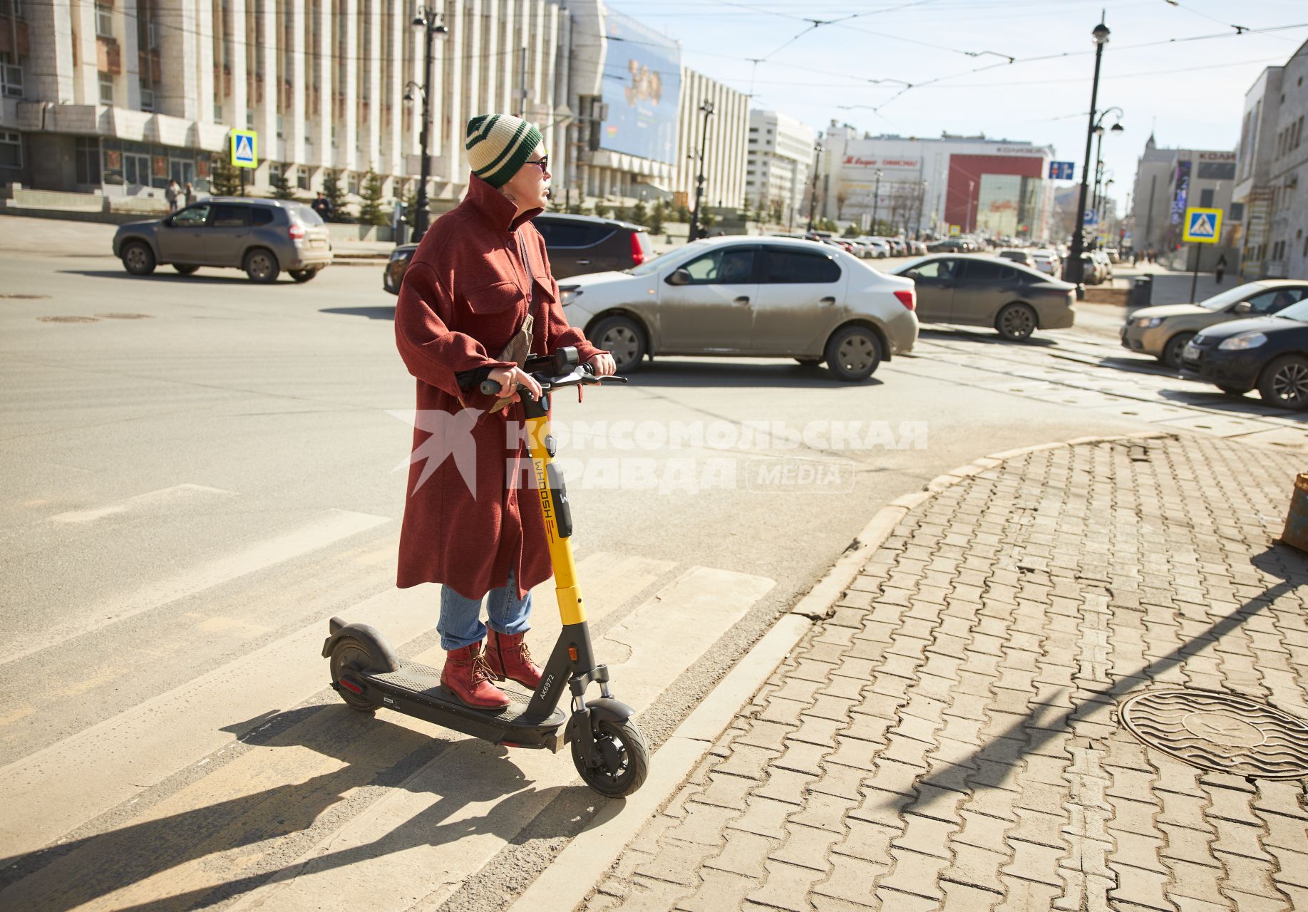 Пермь. Девушка на электросамокате едет по пешеходному переходу.