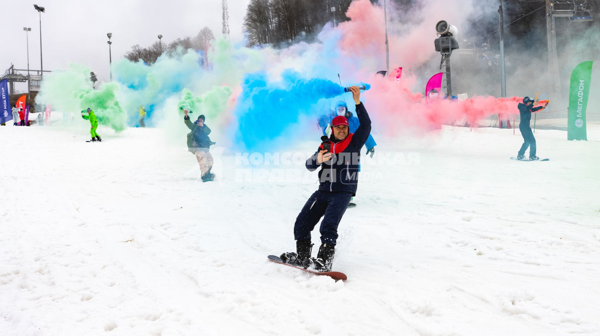 Сочи. Участники фестиваля BoogelWoogel с зажженными дымовыми шашками во время тематического спуска `Цветной дым` на Роза Хутор.