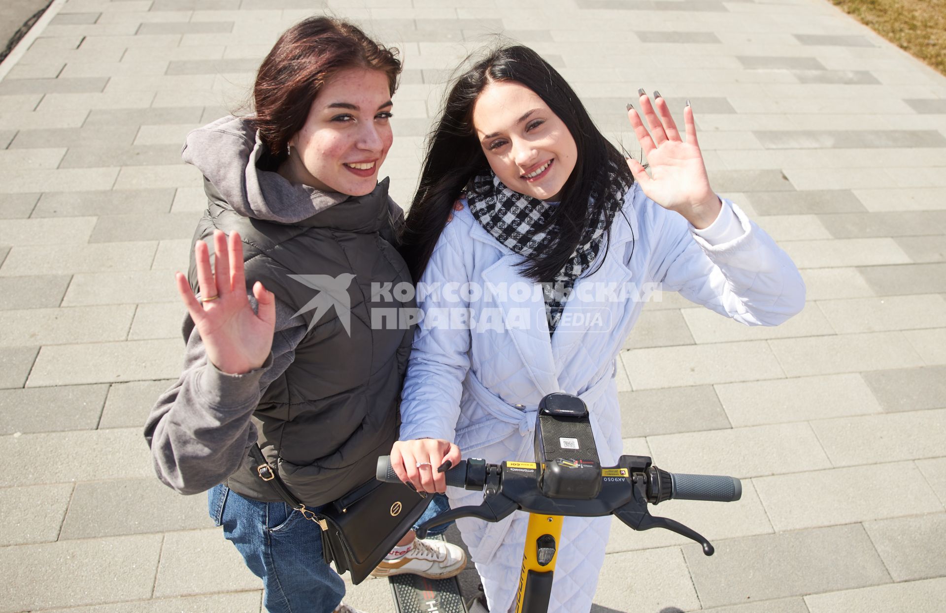 Пермь. Девушки с электросамокатом стоят на улице.